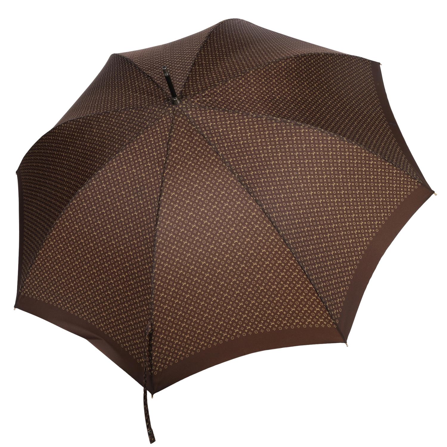 Authentique parapluie-parasol Monogram de Louis Vuitton en marron. Monogramme marron et beige et long manche en bois. 

Excellente qualité avec une touche de mode. Le style classique et la qualité supérieure de ce parapluie Louis Vuitton le rendent