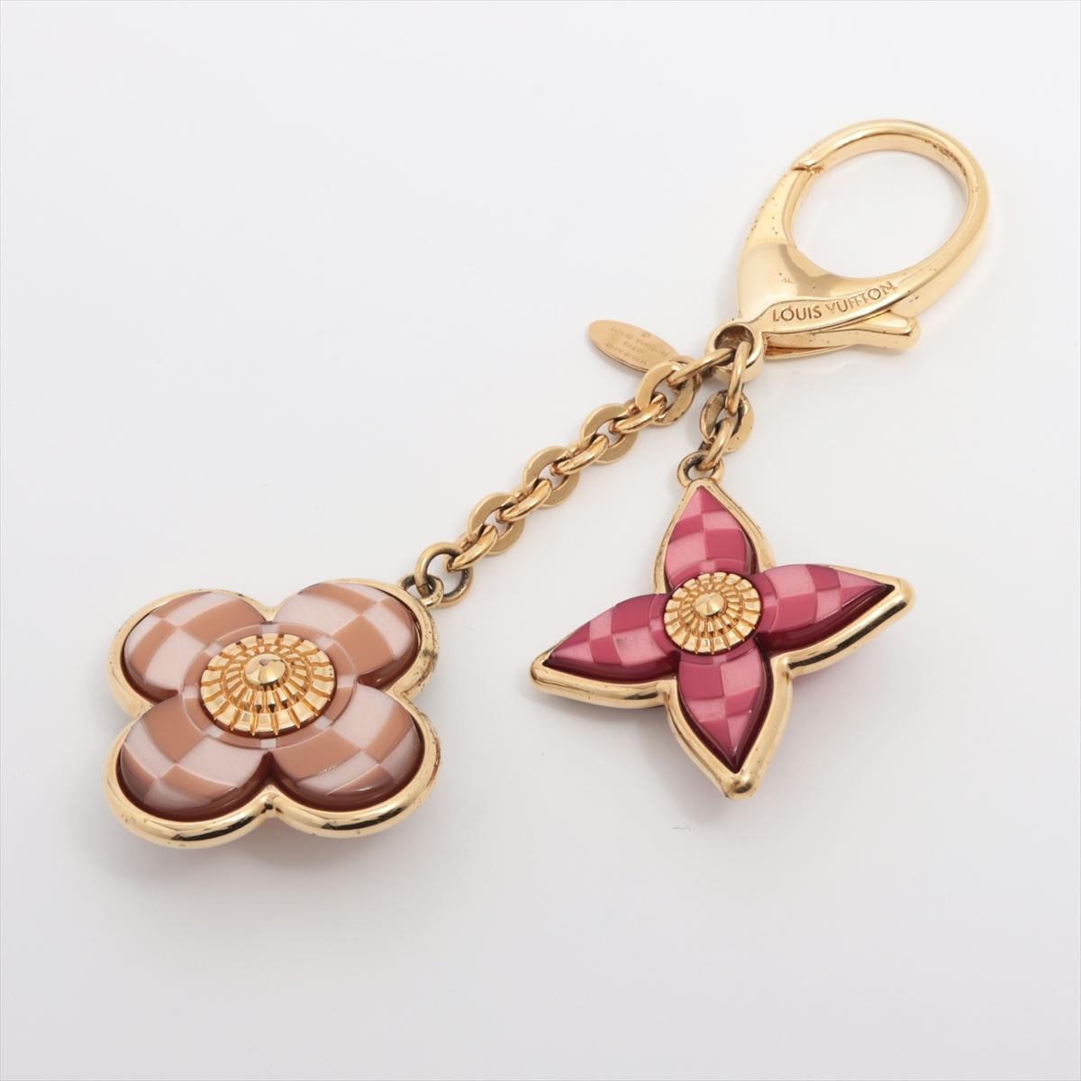 The Louis Vuitton LV Mosaic Flower Bicolor Bag Charm is a captivating and distinctive accessory that reflects the brand's commitment to luxury and innovation. The bag charm features a striking mosaic flower design with the gold-toned at its center.