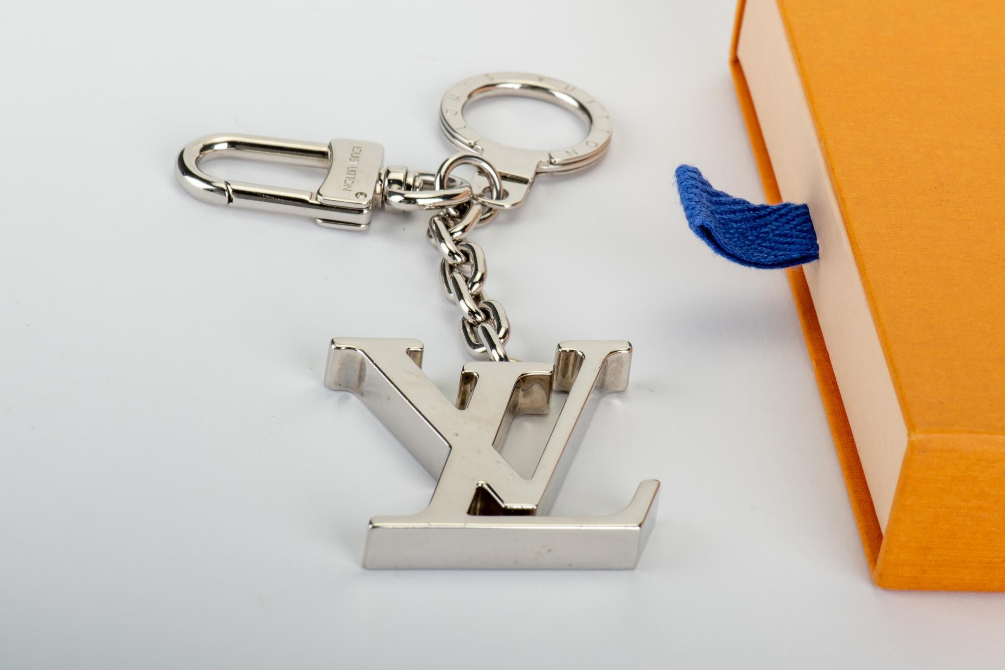 Louis Vuitton logo silver tone keychain/bag charm. Comes with original box.