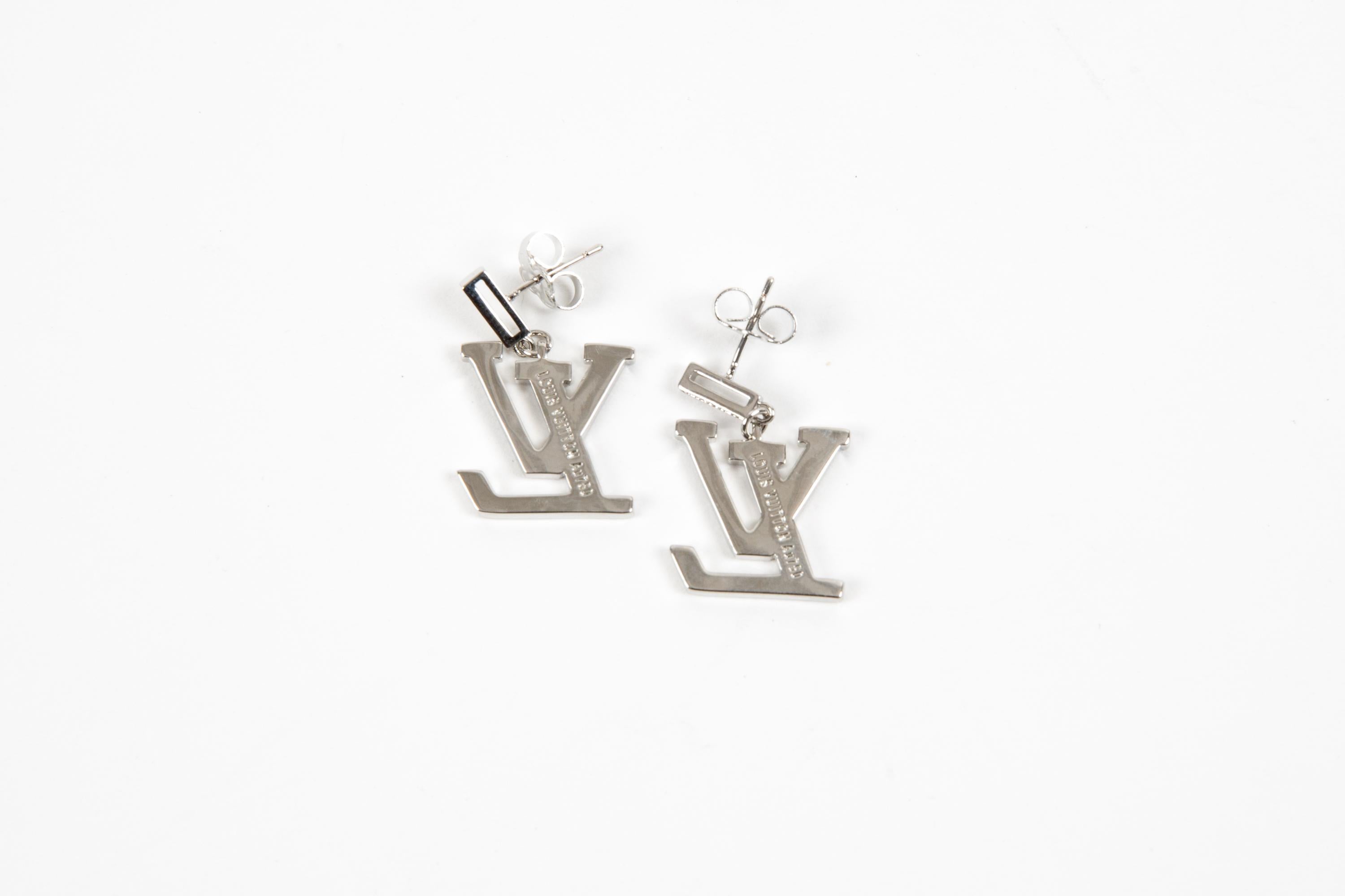 Pendientes largos Louis Vuitton LV en tono plateado, con un gran cristal libre adornado con la inscripción 