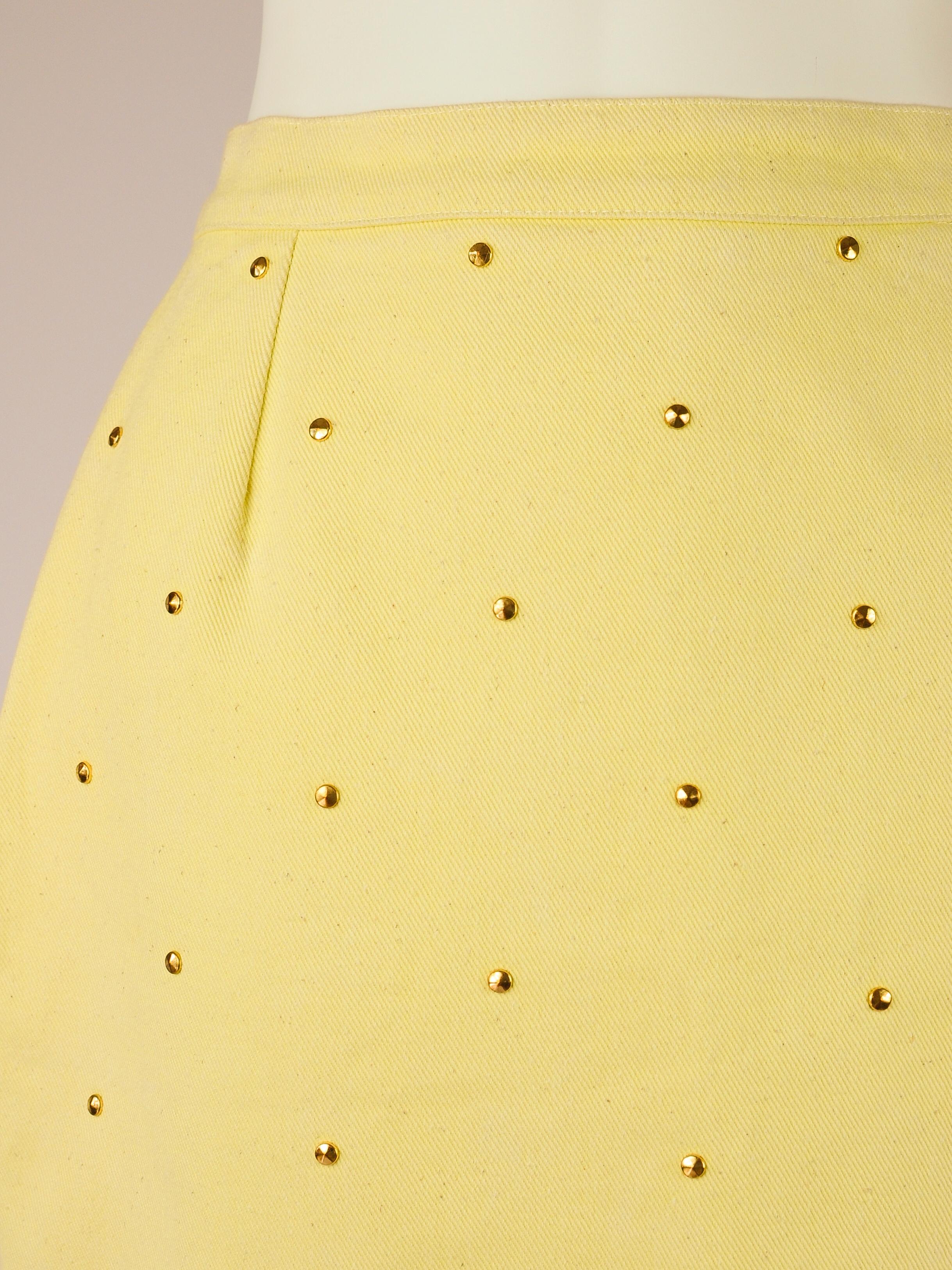 Mini skirt by the LV Sportswear 1980s diffusion line from Louis Vuitton in a fresh lemon yellow with golden stud embellishment. It features a size zipper and a LV embossed stud shaped button on the left side. 

BRAND DESCRIPTION
LV Sportswear was