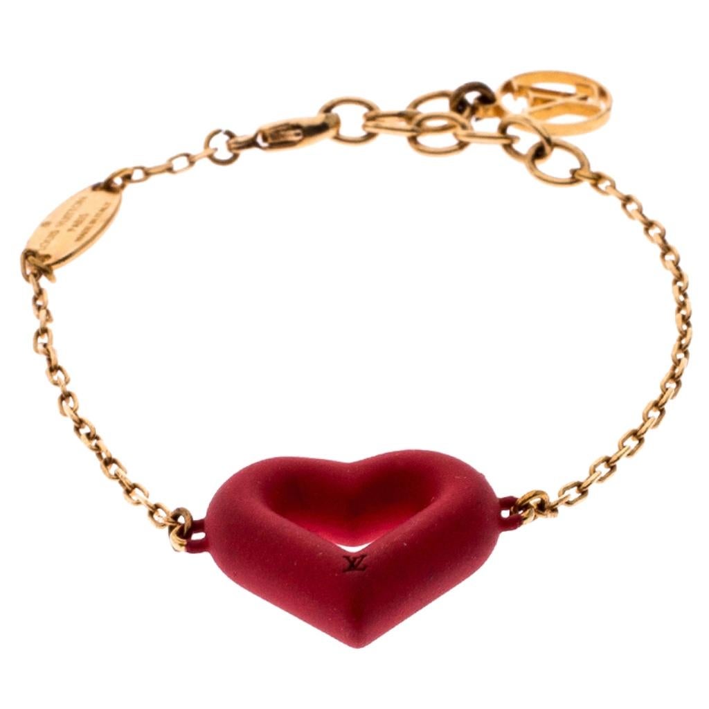 Dainty and elegant, this bracelet from Louis Vuitton is a versatile beauty that can be worn to any occasion. It features a gold-tone chain that holds a red rubber heart charm detailed with the LV logo. A lobster clasp is provided to help fasten the