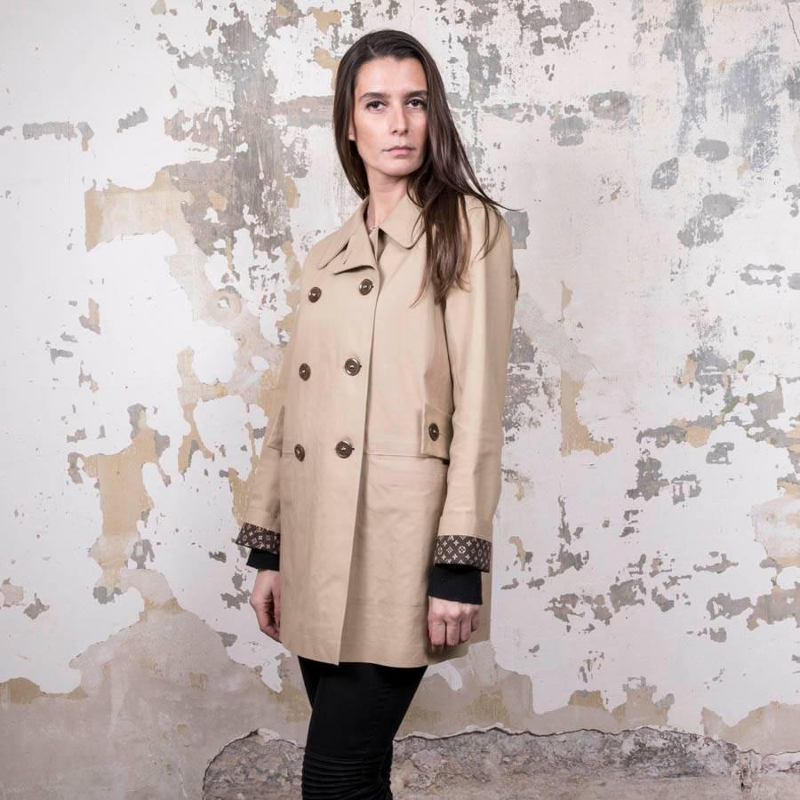 Louis Vuitton Mackintosh raincoat in beige waterproof cotton. Removable belt. Two slit pockets. Brown monogram lining. 
Size 42EU

Very good used condition. Made in Scotland.

Dimensions flat: Shoulder width 42 cm, underarms 53 cm, overall height 75