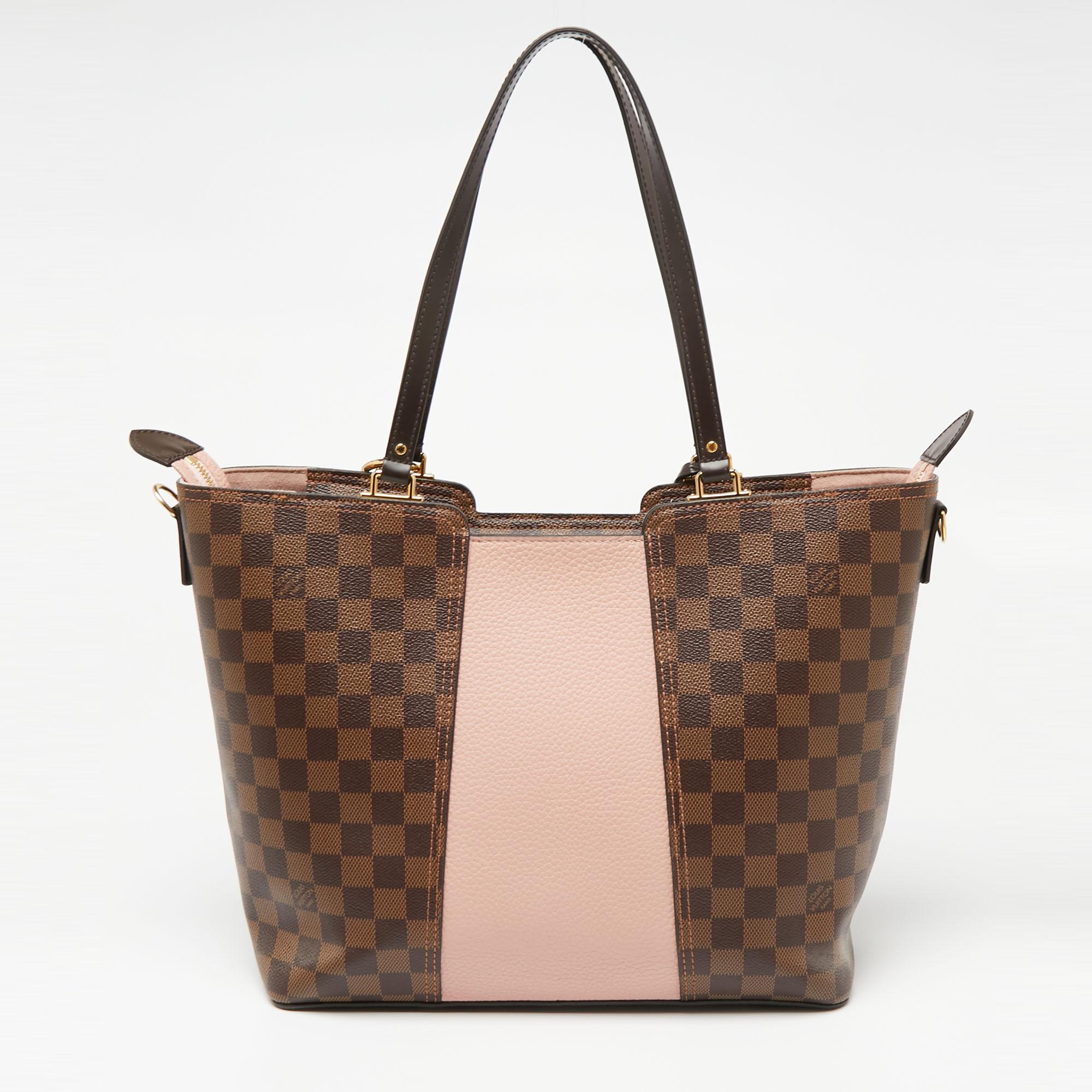 The employment of the signature Damier canvas in its construction gives this Louis Vuitton tote a luxe update. It features a brand-detailed Taurillon leather panel, a shoulder strap, and dual handles. Lined with Alcantara, the interior is secured by