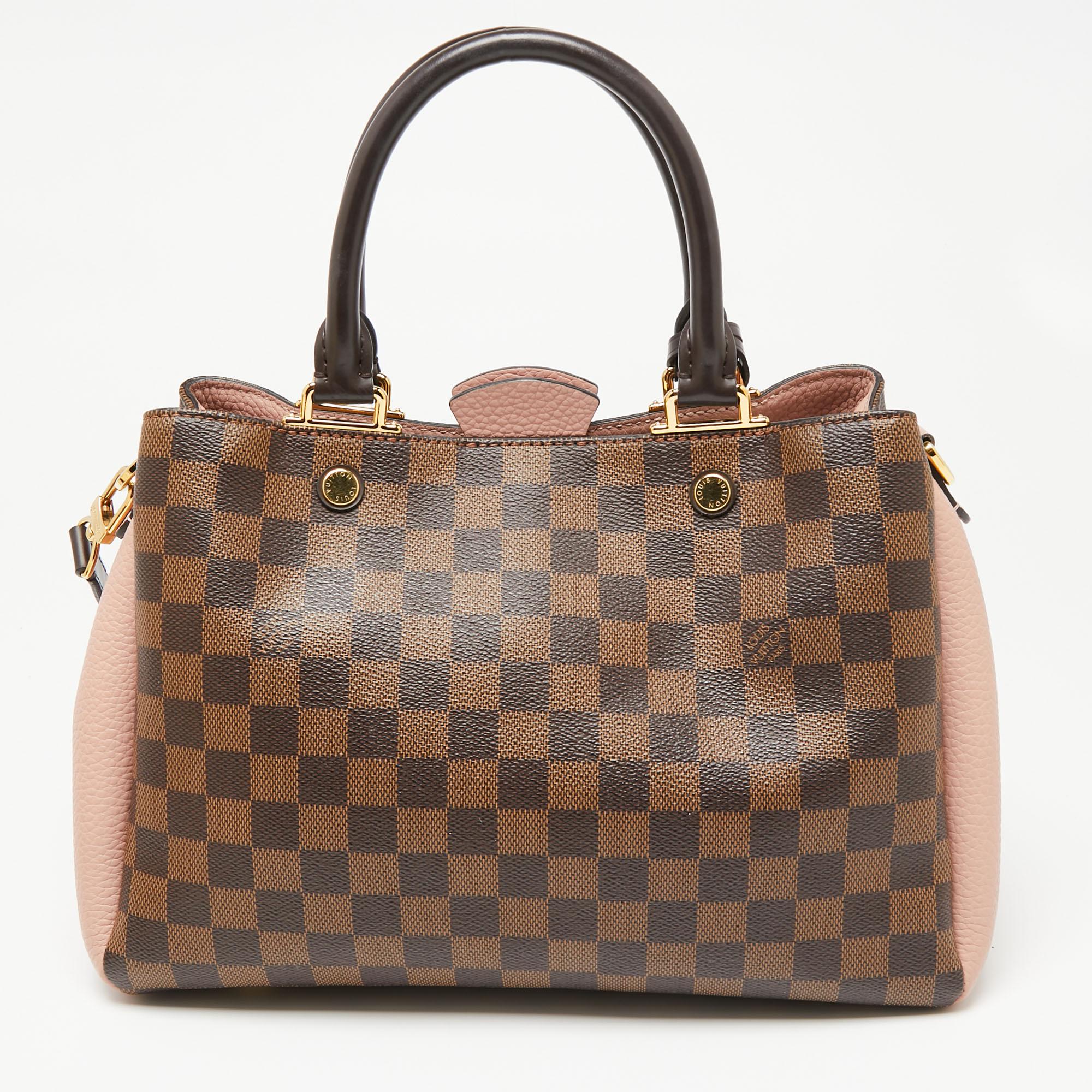 This Brittany handbag, from the house of Louis Vuitton, exhibits utility and classic appeal. It is crafted using Damier Ebene canvas and leather. With Alcantara lining, two top handles, and an optional strap, this bag will be an indispensable