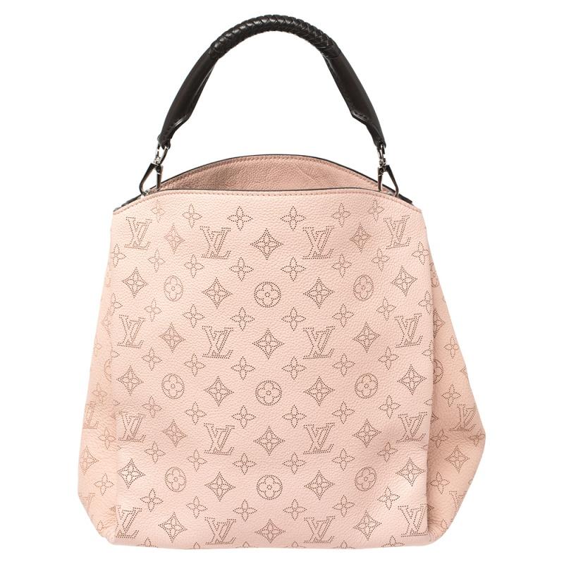 This Babylone bag from Louis Vuitton, like all the other handbags, is durable and stylish. Crafted from the monogram Mahina leather, the bag comes with a single top handle and metal feet at the bottom. It opens to an Alcantara-lined interior that