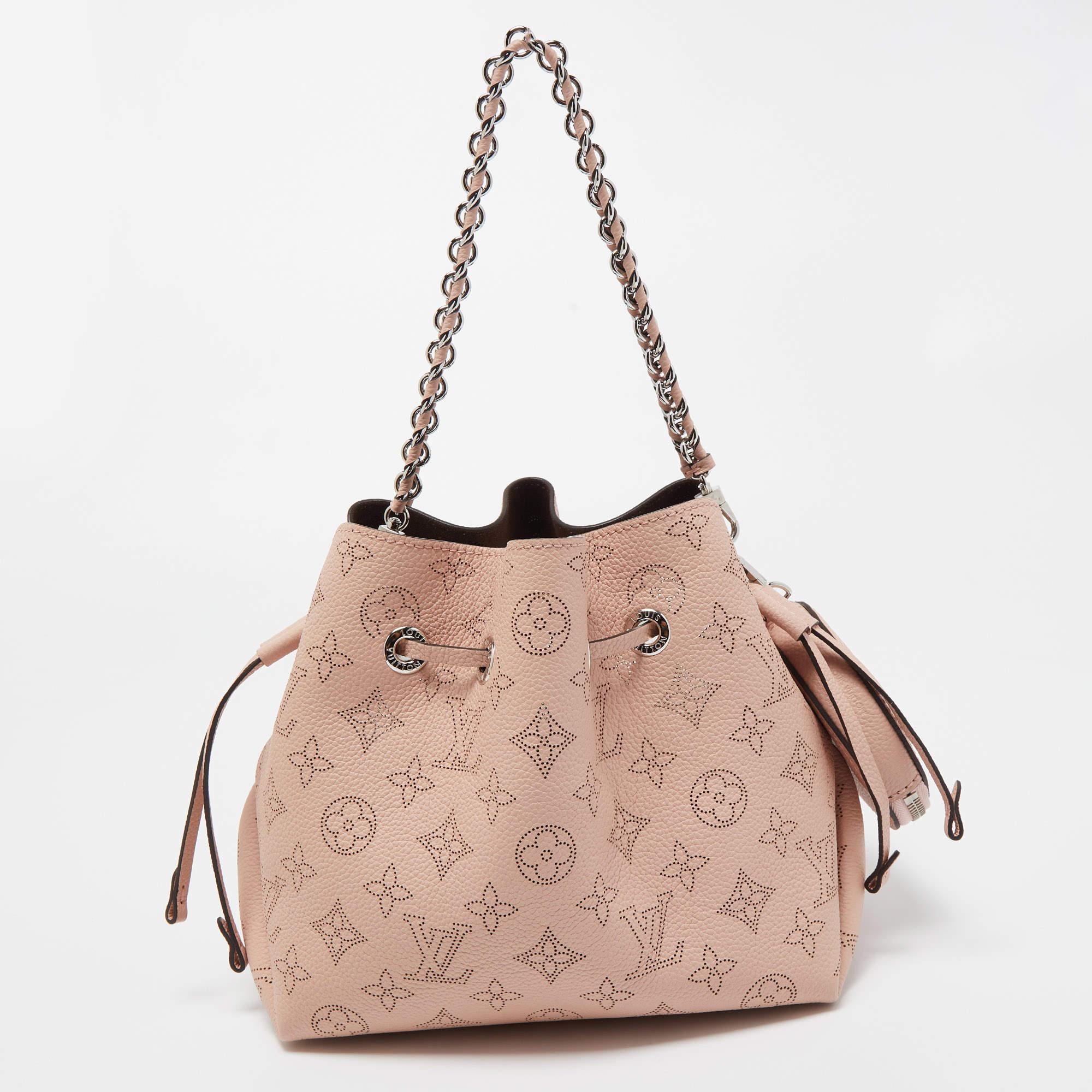 This wonderful Louis Vuitton design is made from Mahina leather and paired with silver-tone hardware. The bag has a bucket shape with a drawstring closure that secures the Alcantara interior. Complete with a chain handle and shoulder strap, it is an