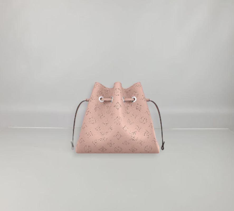 Louis Vuitton stellt die Bella Bucket Bag aus Mahina-Kalbsleder mit perforiertem Monogram-Muster vor. Das kleine Format der Tasche und das runde Portemonnaie, das auf einer Seite eine Miniaturversion des perforierten Monogram-Motivs zeigt, machen
