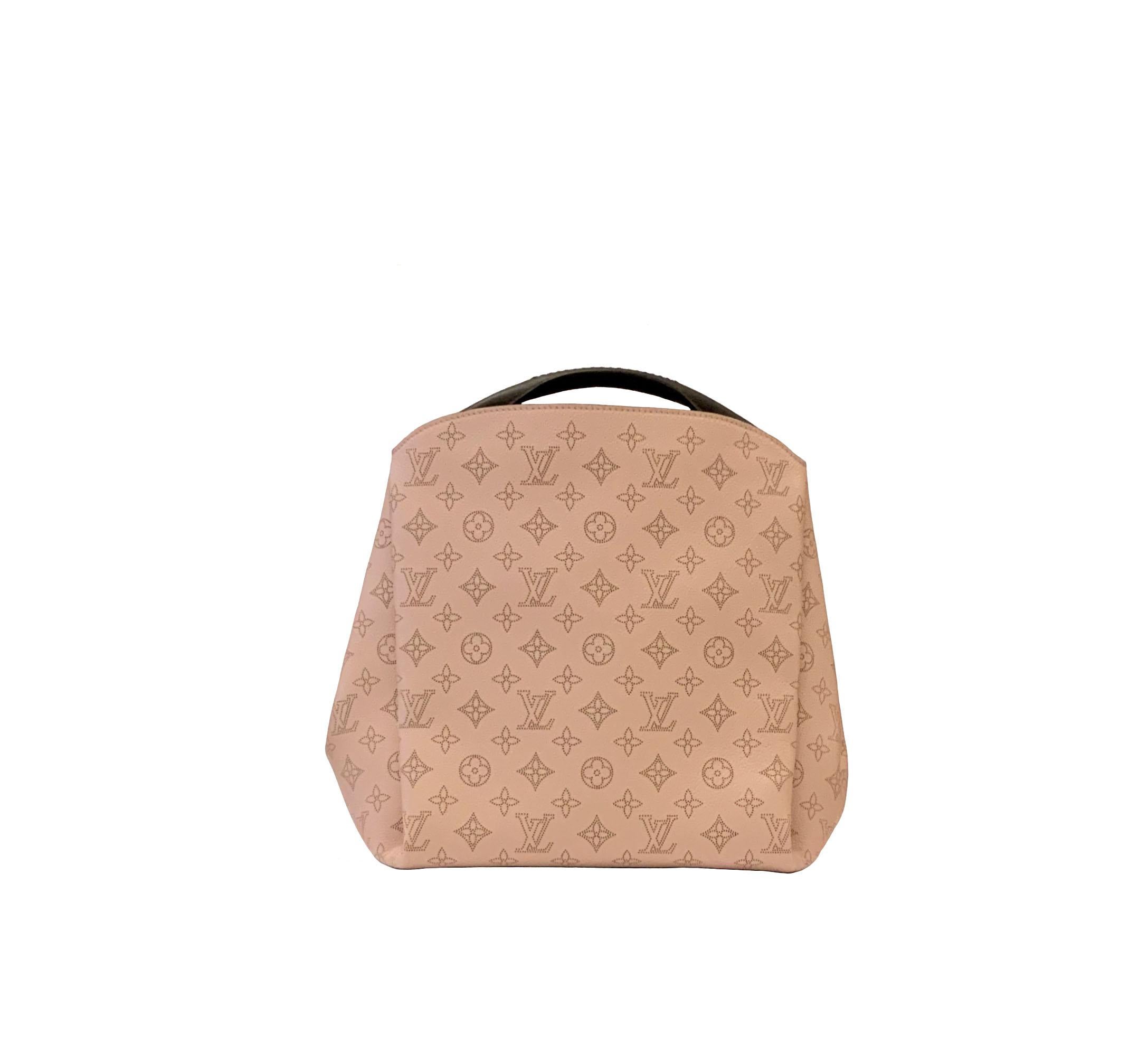 This pre-owned and new Louis Vuitton bag is crafted in Mahina calfskin leather with intricate perforation work which makes a discrete monogram pattern.
It features a removable braided and elbow handle as well as a removable calfskin shoulder strap