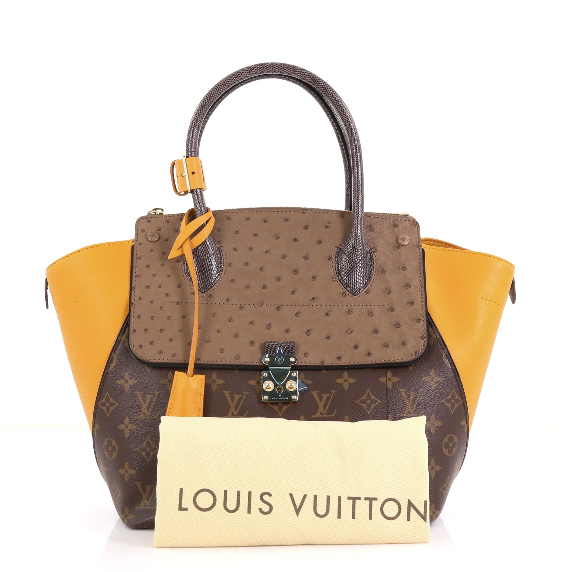 This Louis Vuitton Majestueux Tote Monogram Canvas and Exotics MM, crafted in brown monogram coated canvas and exotics, features an angular silhouette, dual rolled handles, protective base studs, and gold-tone hardware. Its S-lock and zip closures