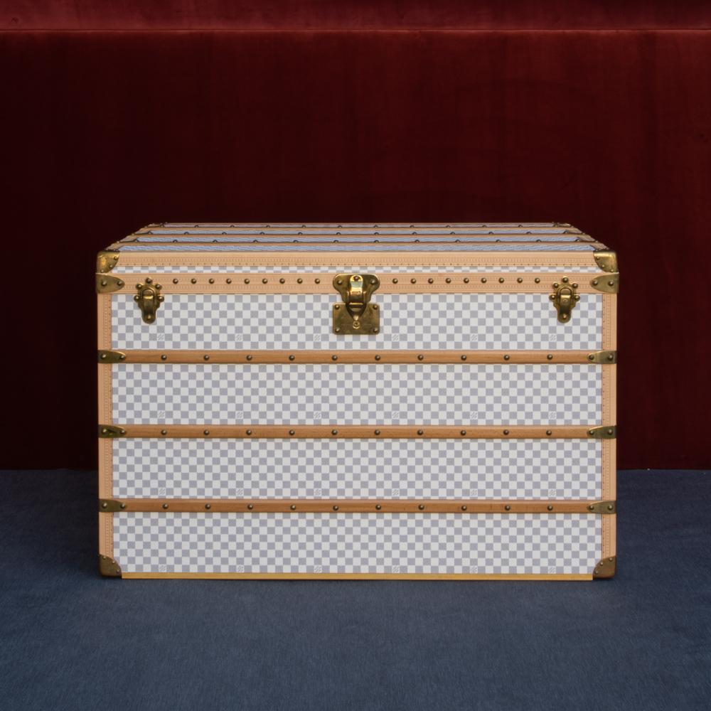 Une magnifique grande malle Louis Vuitton en toile Damier Azur revêtue d'une garniture en cuir et d'accessoires en laiton. Cette malle a été achetée à l'origine au magasin phare de Louis Vuitton Paris en 2007. 
A l'intérieur, le coffre est complet