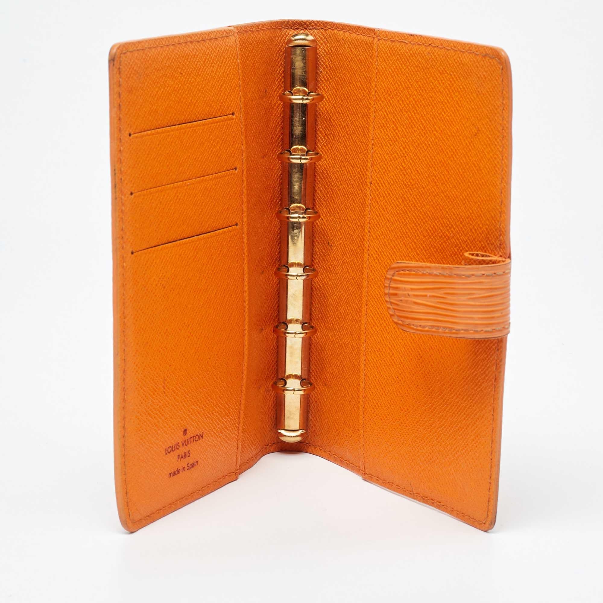 Creaciones funcionales como ésta de Louis Vuitton merecen la pena. Esta funda de agenda tiene un exterior de piel Epi diseñado en estilo díptico con ranuras y anillas doradas para papeles en el interior.
