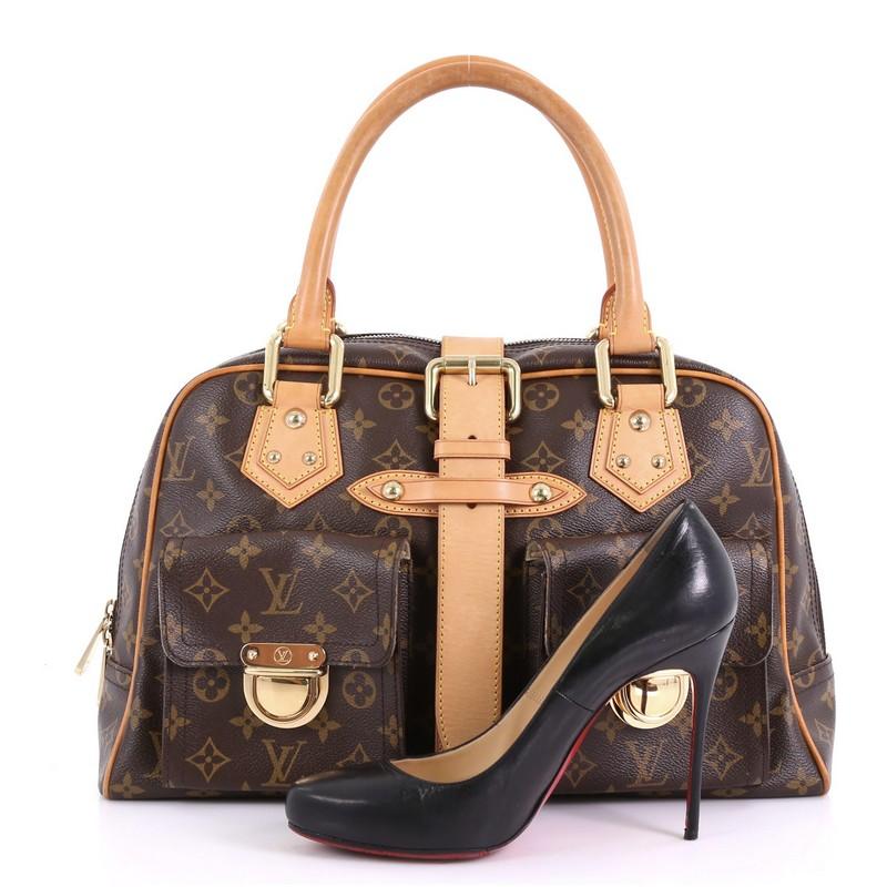 This Louis Vuitton Manhattan Handbag Monogram Canvas GM, crafted in brown monogram coated canvas, features dual rolled vachetta leather handles, front pockets with push-lock closure, and gold-tone hardware. Its top zip closure opens to a beige