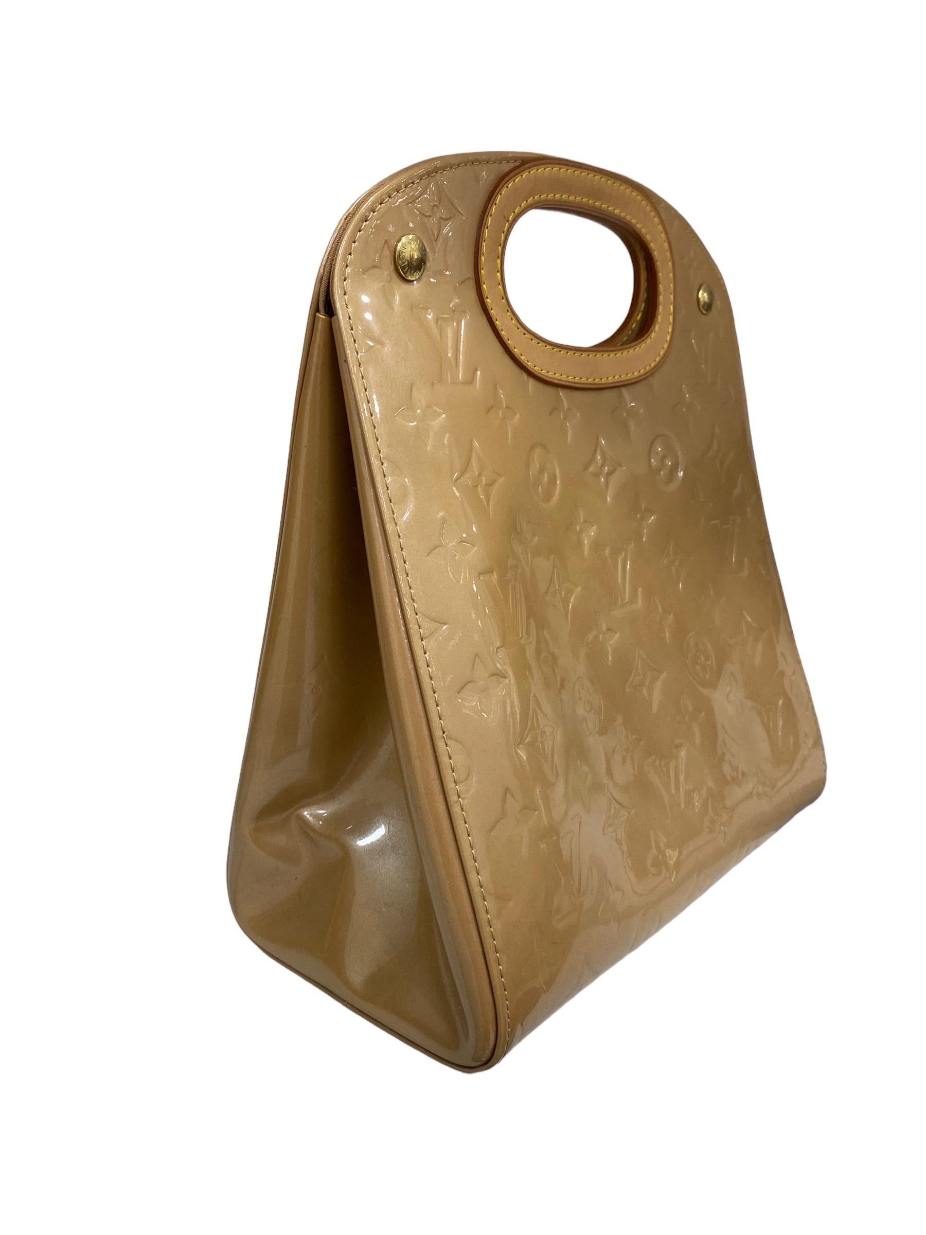 Louis Vuitton bag, Maple Drive model, made in beige patent leather with cowhide inserts and golden hardware. Equipped with a closure with buttons laterally to the openings for the handle, internally lined in beige canvas, quite roomy. Equipped with