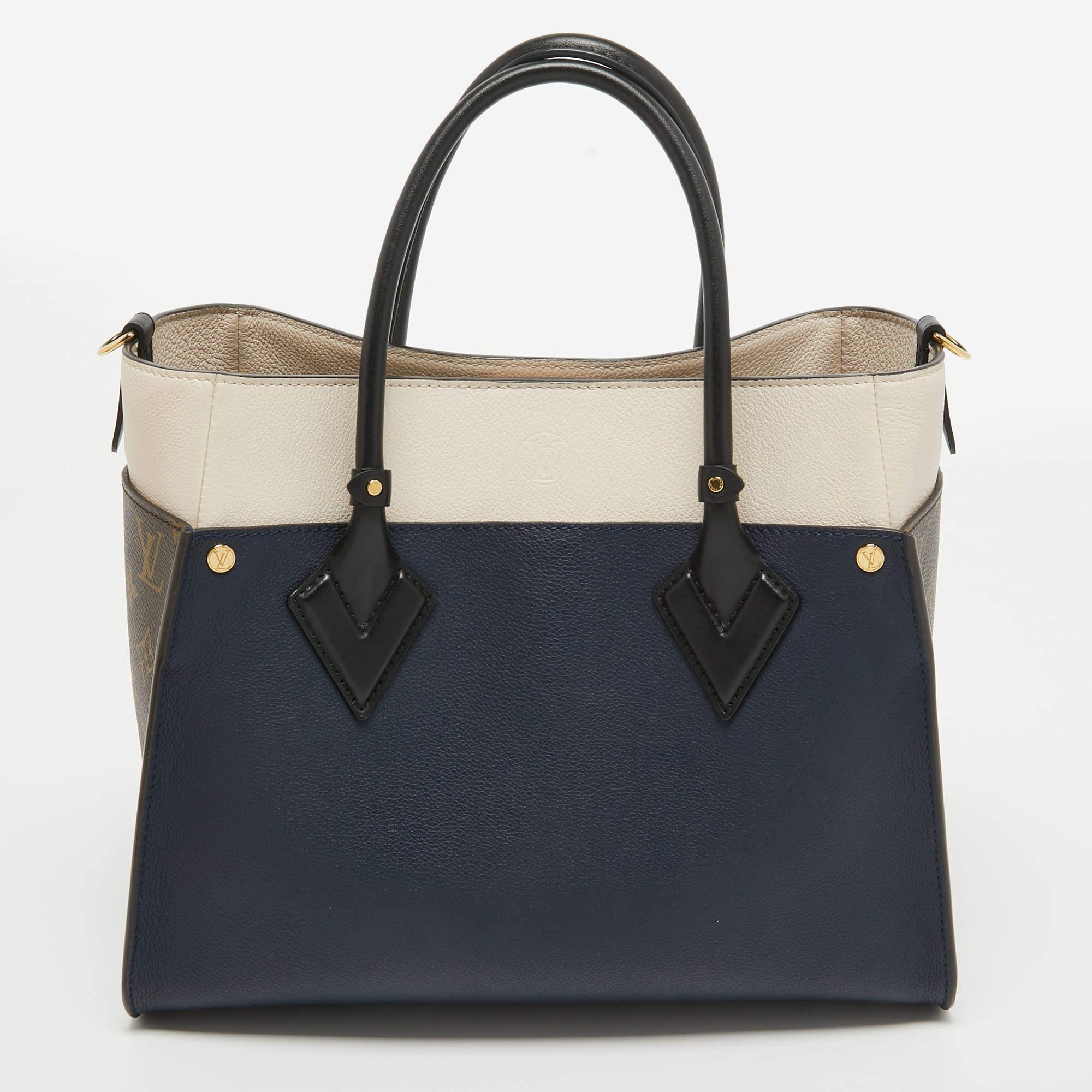The Louis Vuitton On My Side Bag is a luxurious accessory featuring the iconic LV monogram in navy blue on durable canvas. Trimmed with supple leather, it boasts a spacious interior, adjustable shoulder strap, and gold-tone hardware, exemplifying