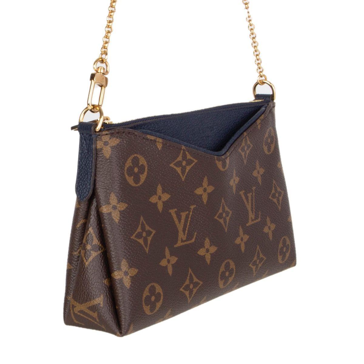 Louis Vuitton 'Pallas' clutch in brown and olive monogram canvas with midnight blue grained leather featuring slip outside pocket. Opens with a zipper on top and is lined in midnight blue canvas with one open pocket against the back. Comes with a