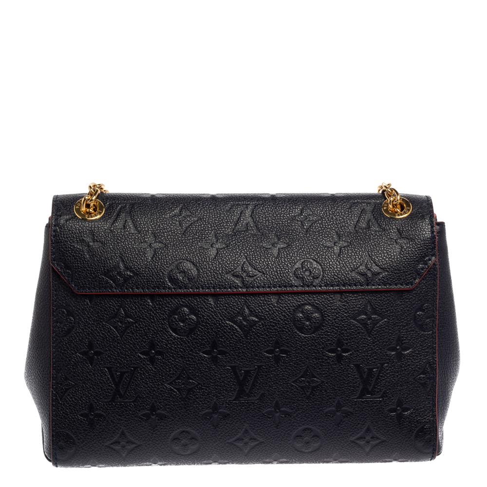 This Louis Vuitton Saint Sulpice bag carries oodles of style and sophistication. Crafted in France, it is made of Monogram Empreinte leather. It comes in a lovely shade of blue. It has a flap top with a gold-tone push-lock closure that accentuates
