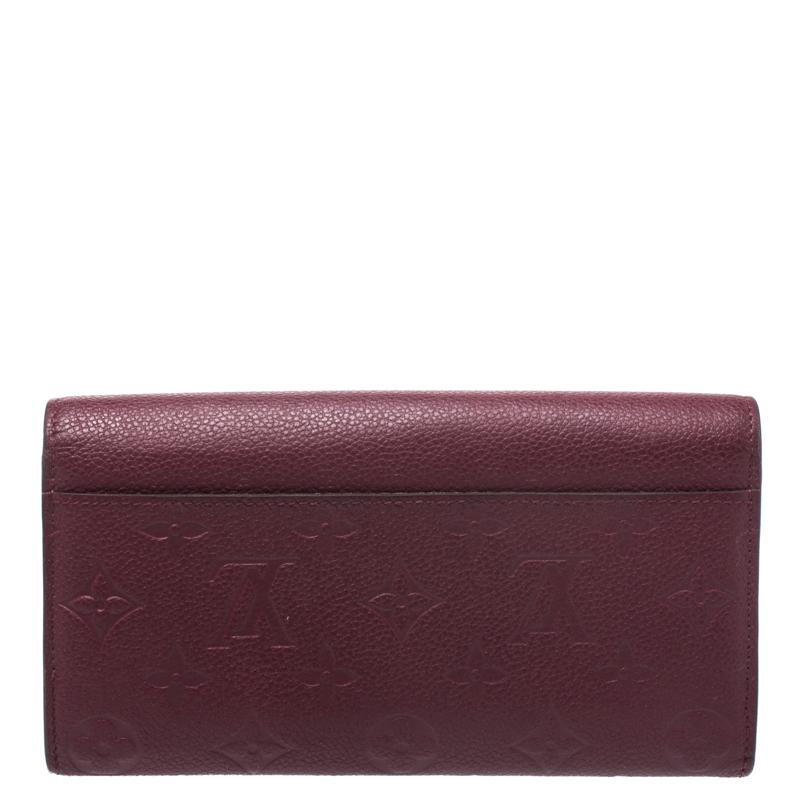 One of the most famous wallets by Louis Vuitton is the Sarah. This one here comes made from Monogram Empreinte leather and the button on the flap opens to an interior with multiple card slots and a zip pocket. Perfect in size, this wallet can easily