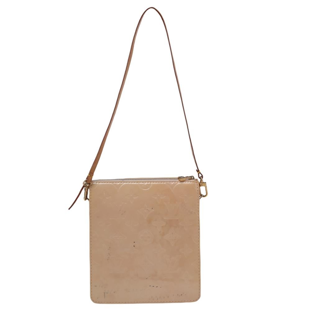 This Mott bag by Louis Vuitton will make for a smart purchase. crafted from beige Monogram Vernis, it features a detachable shoulder strap along with a flap pocket on the front. The top zip closure opens to a leather-lined interior. This bag will