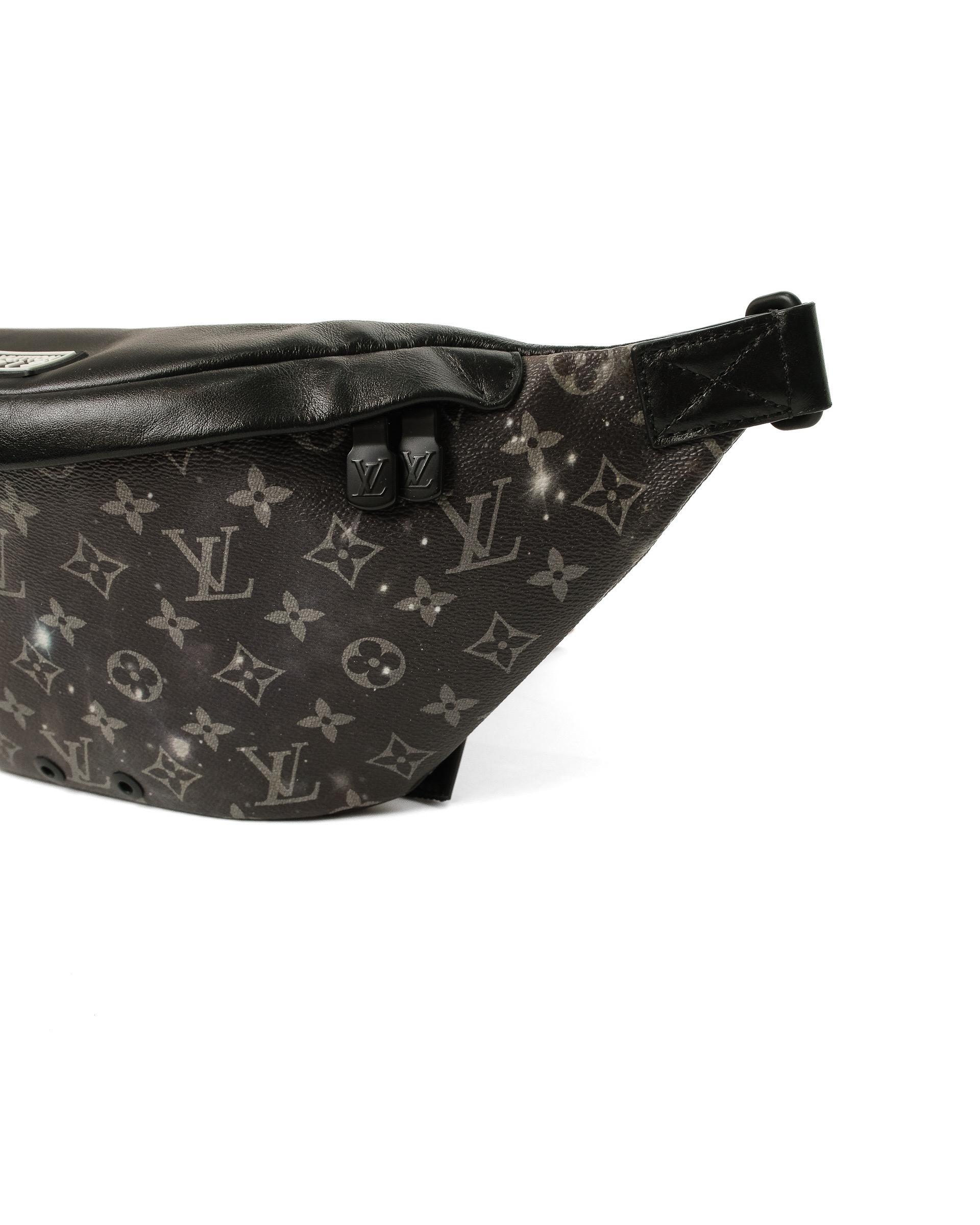 Marsupio firmato Louis Vuitton, modello Discovery, misura PM, in edizione limitata, collezione Galaxy. Realizzato in tela monogram Black Multicolor con hardware neri. Dotato di un chiusura superiore a zip, internamente rivestito in tessuto nero,