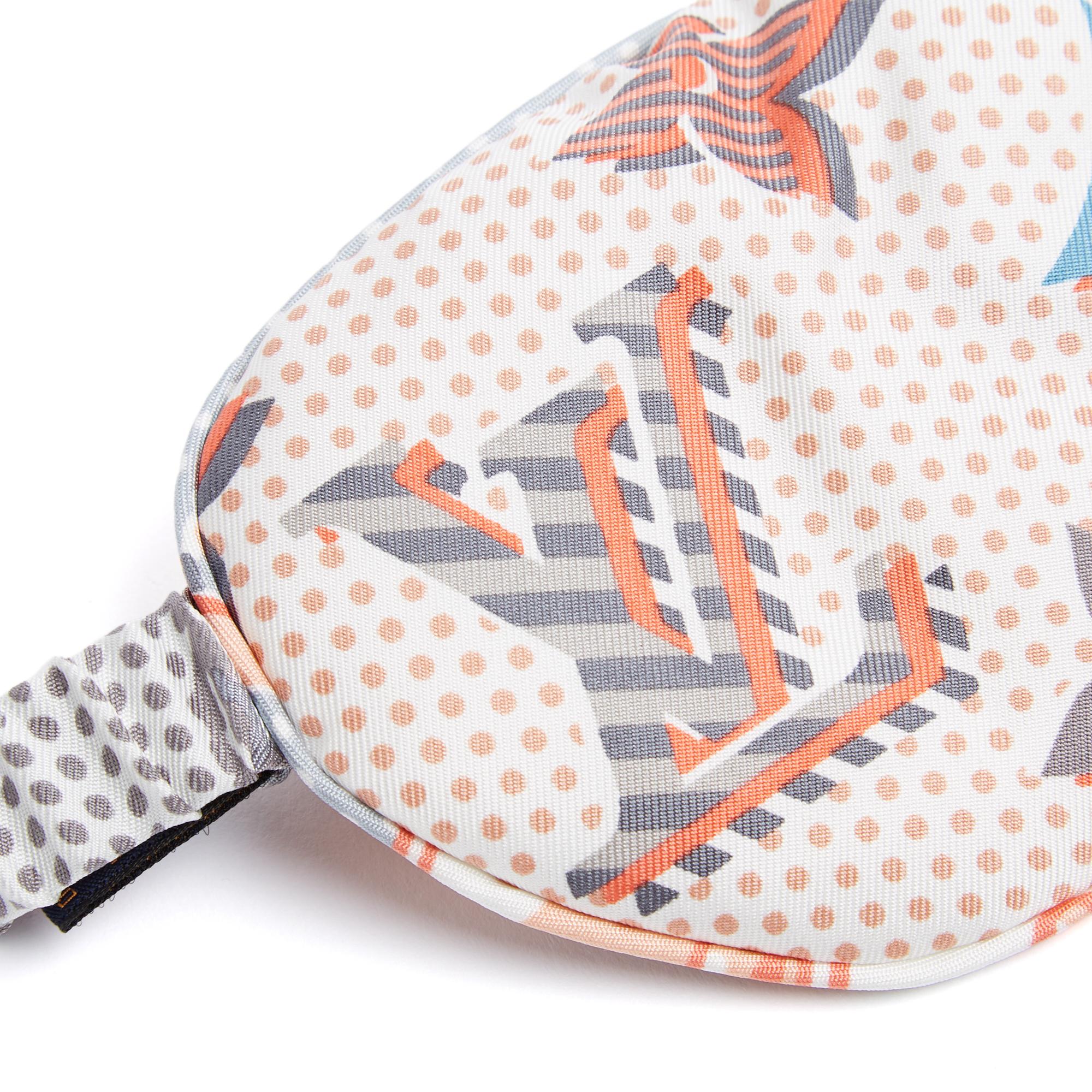Antifaz para dormir Louis Vuitton de sarga de seda color crudo estampado con lunares y motivo Monograma, provisto de una banda elástica para ajustarlo a todas las tallas, entregado en su bolsa original de seda a juego, firmado. El artículo no se ha