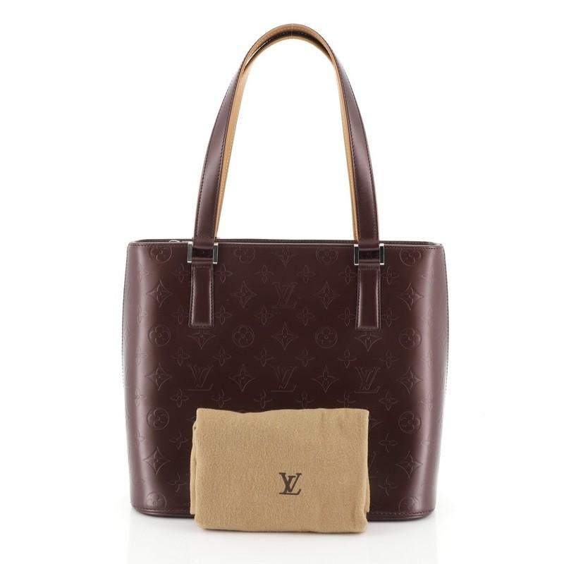 This Louis Vuitton Mat Stockton Handbag Monogram Vernis, crafted from purple monogram vernis, features dual flat handles, vachetta leather trim, and matte silver-tone hardware. Its zip closure opens to a pink fabric interior with side zip and slip