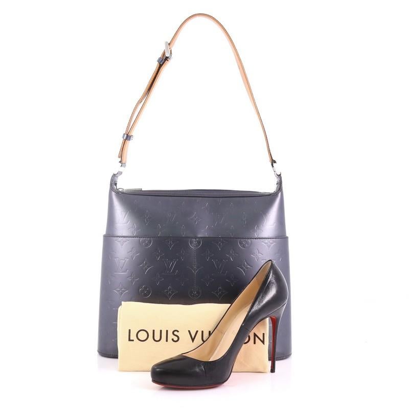 This Louis Vuitton Mat Sutter Bag Monogram Vernis, crafted from navy monogram mat vernis leather, features a long strap, four exterior slip pockets, and silver-tone hardware. Its zip closure opens to a navy fabric interior with side slip pockets.