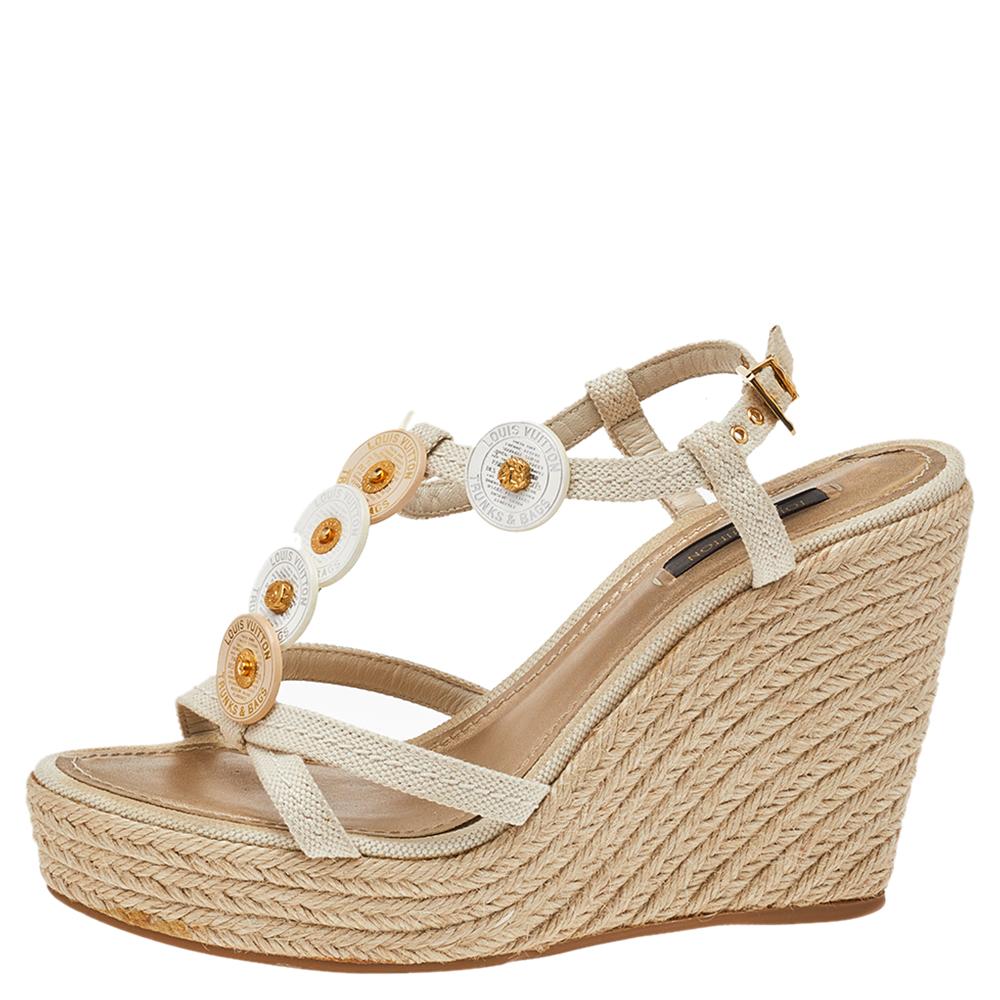 Walk with comfort in these lovely sandals from Louis Vuitton! The sandals have been crafted from canvas and styled with medallion details on the vamps. They flaunt ankle closure and espadrille platform wedge heels.