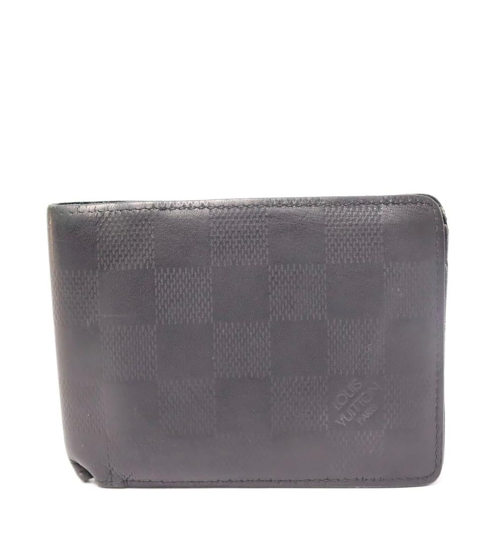 Louis Vuitton Multiple Wallet in embossed Damier Infini leather. 

Material: Leather
Height: 9cm
Width: 12cm
Depth: 2.5cm
Overall condition: Fair
Interior condition: some stains
External condition: light scratches on the leather, leather ripped from