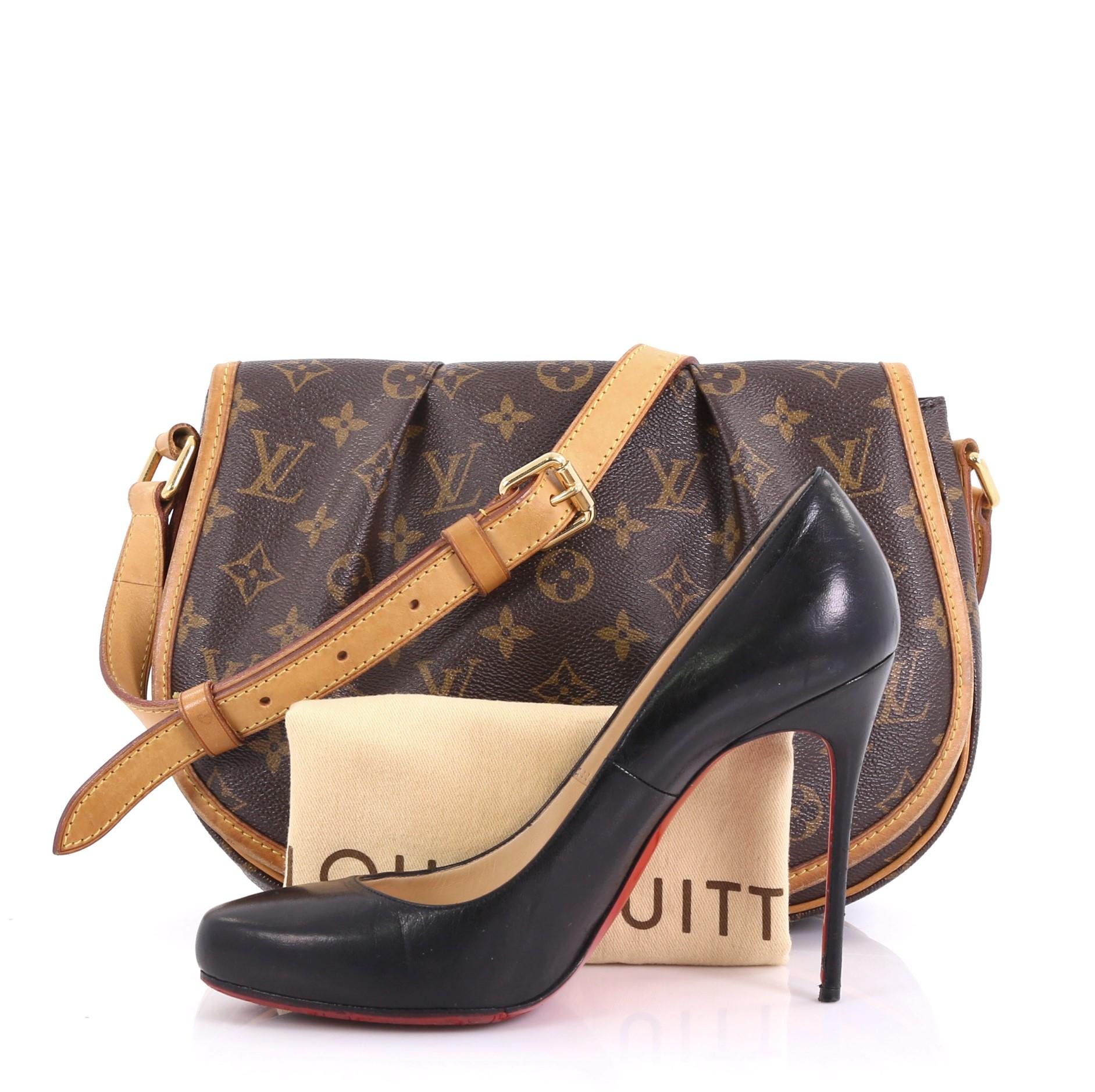 This Louis Vuitton Menilmontant Handbag Monogram Canvas PM, crafted in brown monogram coated canvas, features a full frontal flap with pleated design, flat leather adjustable shoulder strap, and gold-tone hardware. Its hidden magnetic snap closure