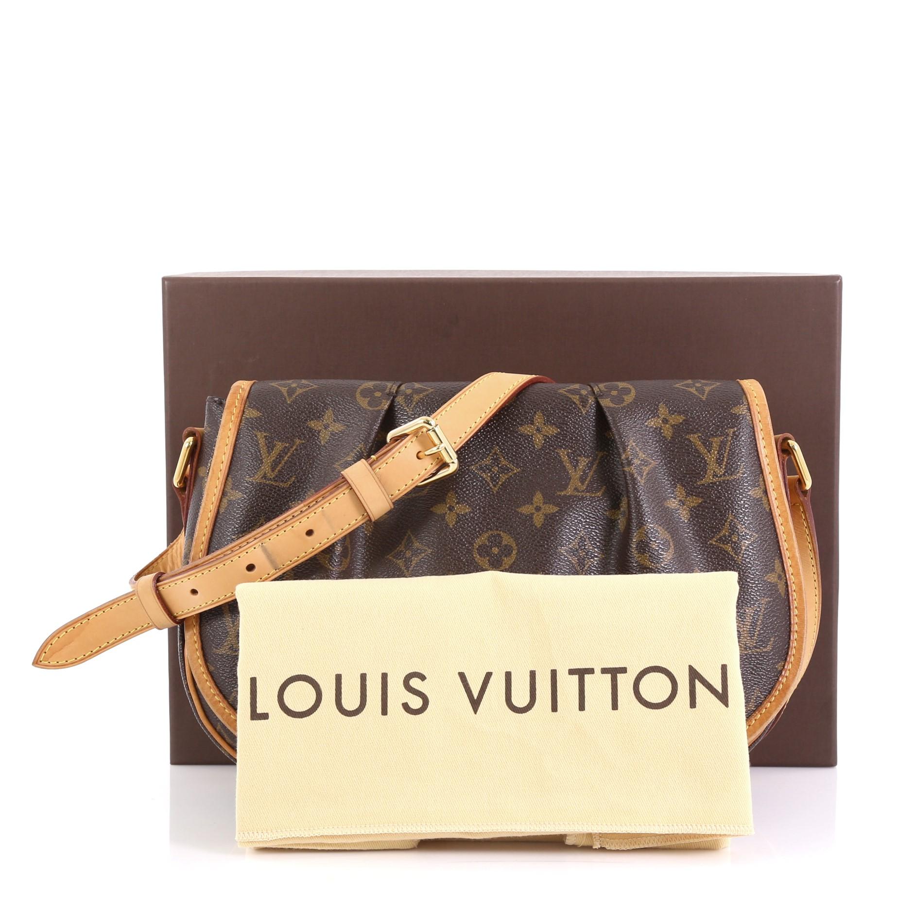 This Louis Vuitton Menilmontant Handbag Monogram Canvas PM, crafted in brown monogram coated canvas, features a full frontal flap with pleated design, adjustable leather strap, and gold-tone hardware. Its magnetic snap closure opens to a brown