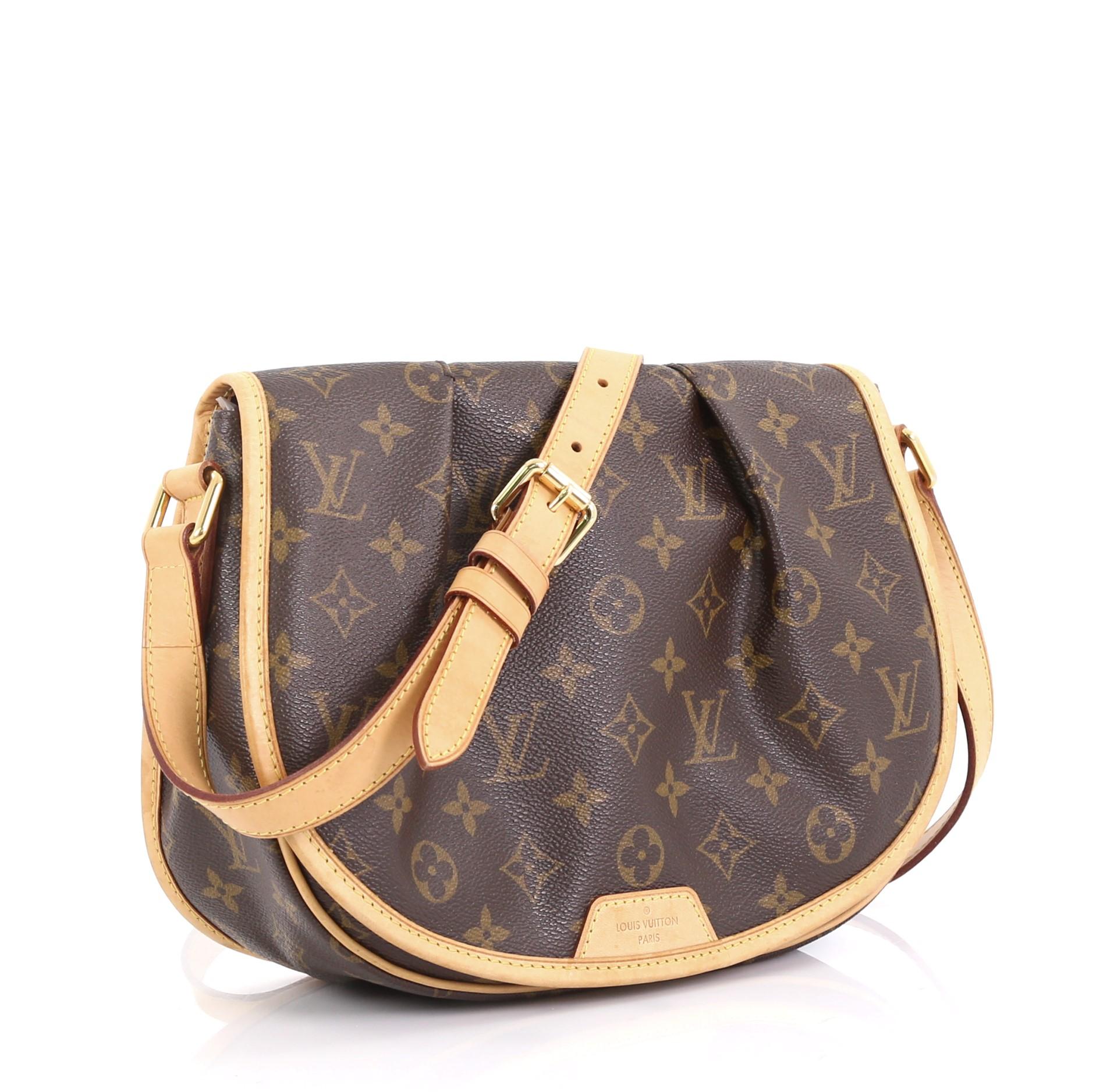 This Louis Vuitton Menilmontant Handbag Monogram Canvas PM, crafted in brown monogram coated canvas, features a full frontal flap with pleated design, flat leather adjustable shoulder strap, and gold-tone hardware. Its hidden magnetic snap closure