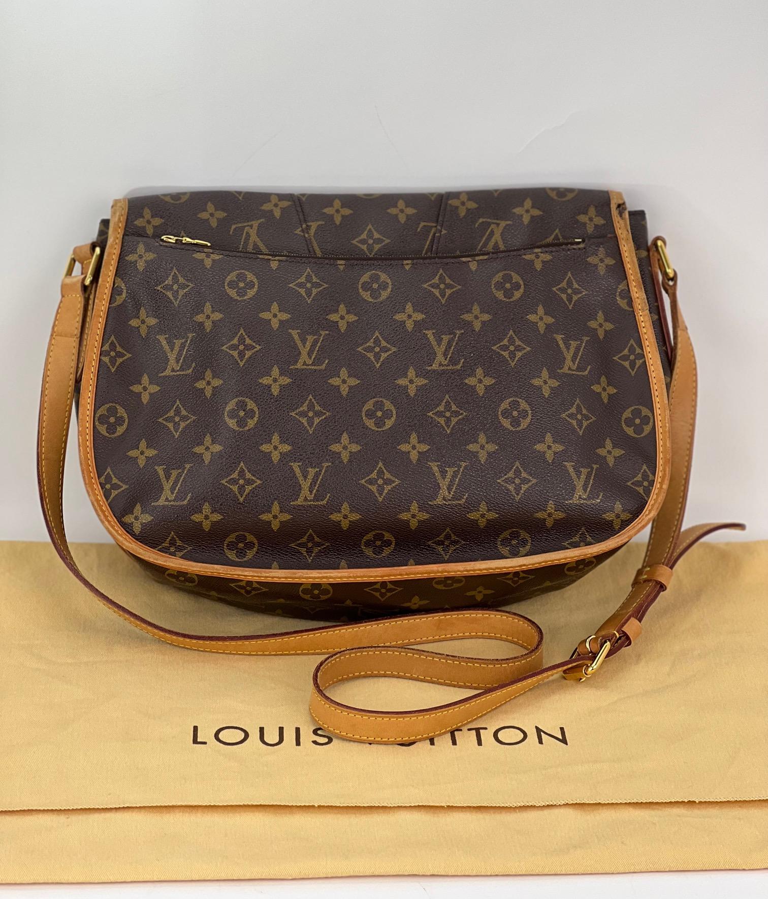 Pre-Owned 100% Authentic
Louis Vuitton Menilmontant MM Monogram
Messenger Bag
RATING: B C   good, shows some
signs of wear
STRAP: adjustable leather, has some light
marks and stains, red piping on side has some wear
DROP: 19'' to 22.5''
PIPING:  has
