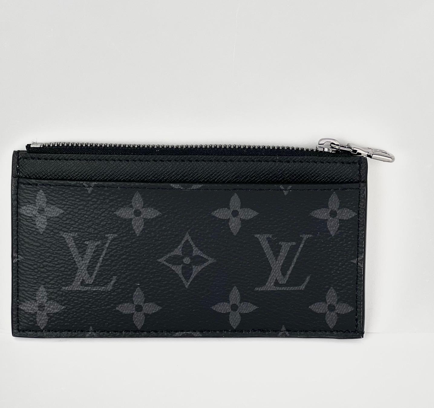 Pre-Owned  100% Authentic
LOUIS VUITTON Reverse Monogram Eclipse Taiga Coin Card
RATING: B...Very Good, well maintained, 
shows minor signs of wear
MATERIAL: reverse monogram eclipse canvas, 
taiga leather
COLOR:  gray, black
EXTERIOR: back pocket