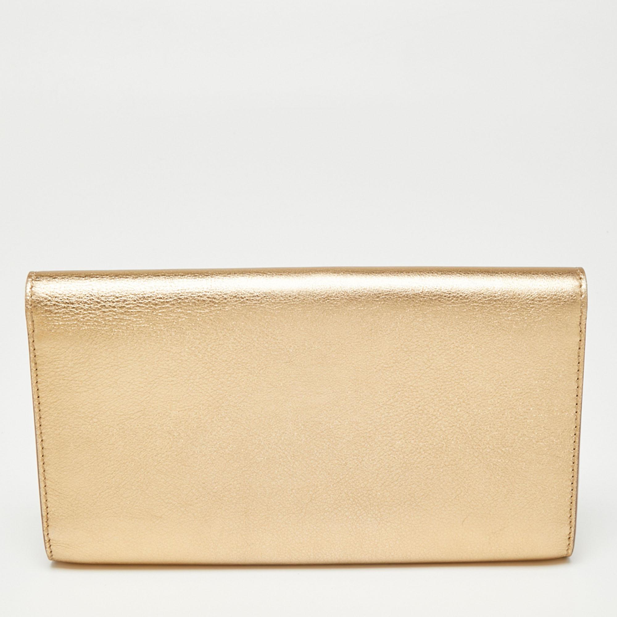 How stunning is this Louise clutch by Louis Vuitton! It is glossy, well-crafted, and overflowing with style. It has a metallic gold leather exterior, an Alcantara interior, and a large LV logo adorned on the flap. This creation will elevate your