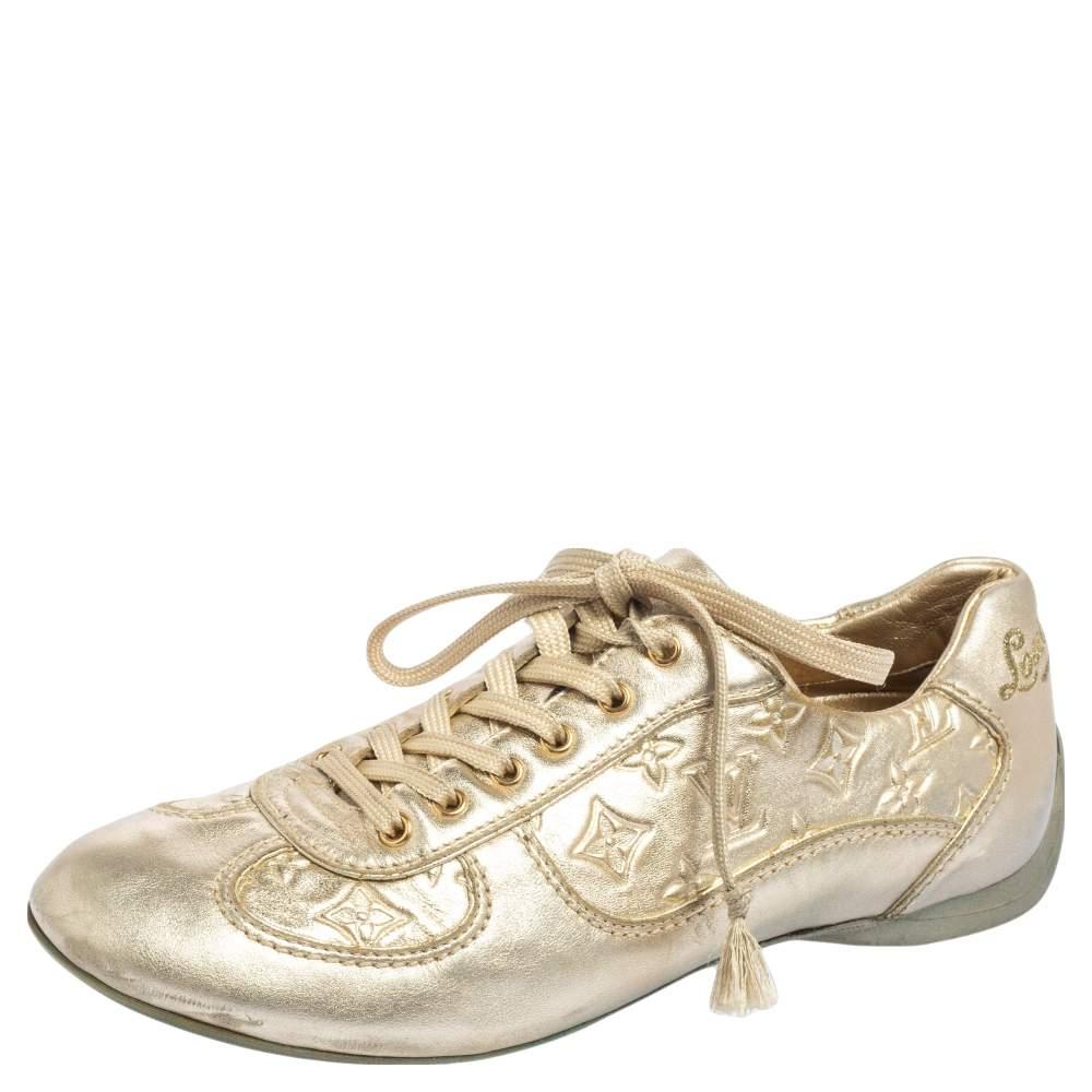 Elevate your casual look with these metallic gold trainers by Louis Vuitton. Crafted from Mahina leather, they feature monogram motifs and simple laces on the vamps. The comfortable shoe is set on a durable rubber sole.