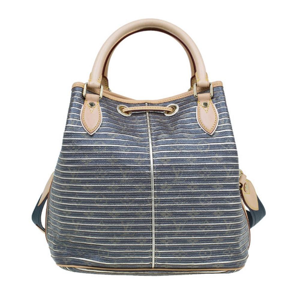 The perfect summer bag, this Louis Vuitton tote is cool and breezy. Made from coated canvas, its exterior features the signature brown leather monogrammed exterior with silver metallic stripes and a beige leather trim. The front features the LV