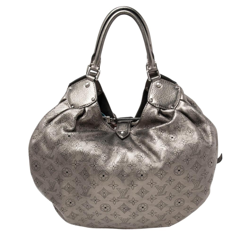 This Louis Vuitton Surya bag is designed exquisitely. Its metallic body is inspired by the Hindu Sun God, Surya. Feminine and chic, this slouchy bag is roomy and perfect for everyday use. Crafted from intricate perforated LV monogram Mahina leather,