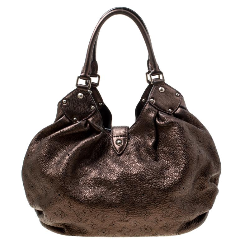 This hobo from the house of Louis Vuitton is a delight to own. Louis Vuitton's Mahina collection was inspired by the crescents of the moon. Featuring a slightly slouchy silhouette the bag comes with dual rolled top handles, buckle detailing on the