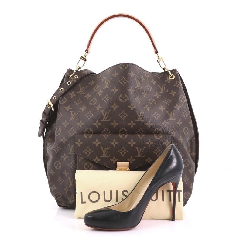 This Louis Vuitton Metis Hobo Monogram Canvas, crafted in brown monogram coated canvas, features front flap pocket with S-lock closure, removable vachetta leather handle, and gold-tone hardware. Its wide top opening showcases a brown microfiber