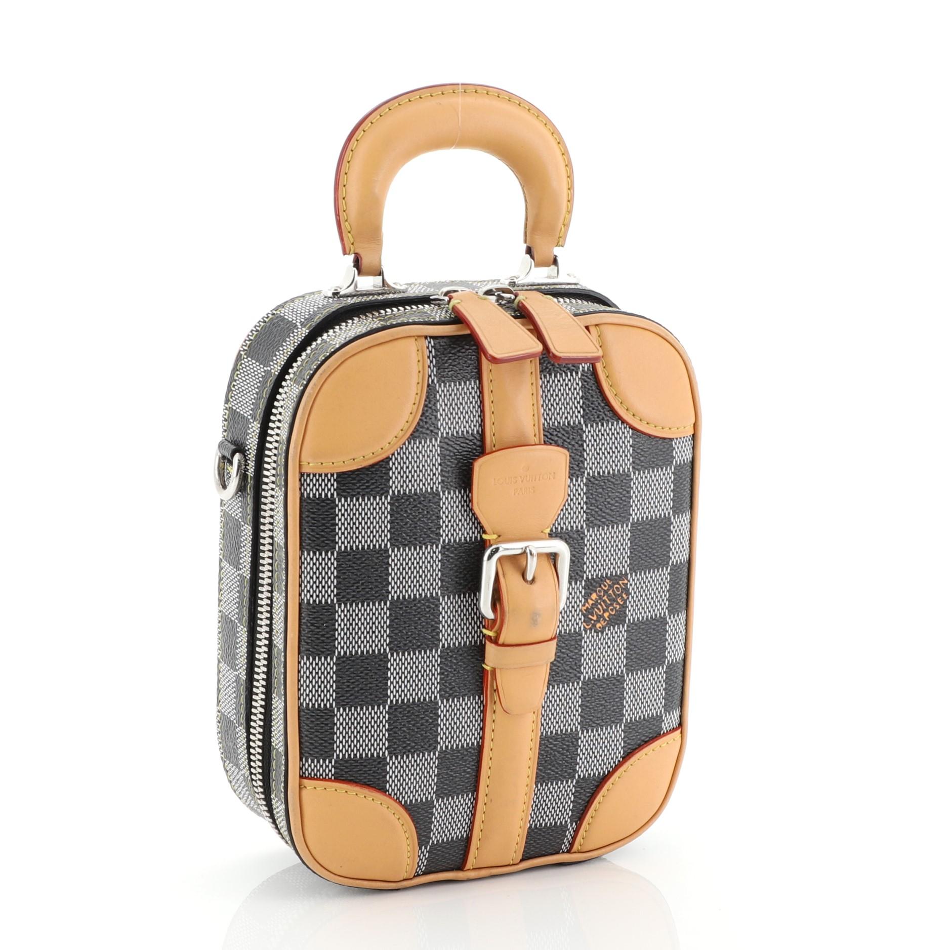 This Louis Vuitton Mini Luggage Vertical Limited Edition Colored Damier, crafted in blue Damier coated canvas, features a rigid handle, adjustable leather strap, metallic buckle and silver-tone hardware. Its zip closure opens to a brown microfiber
