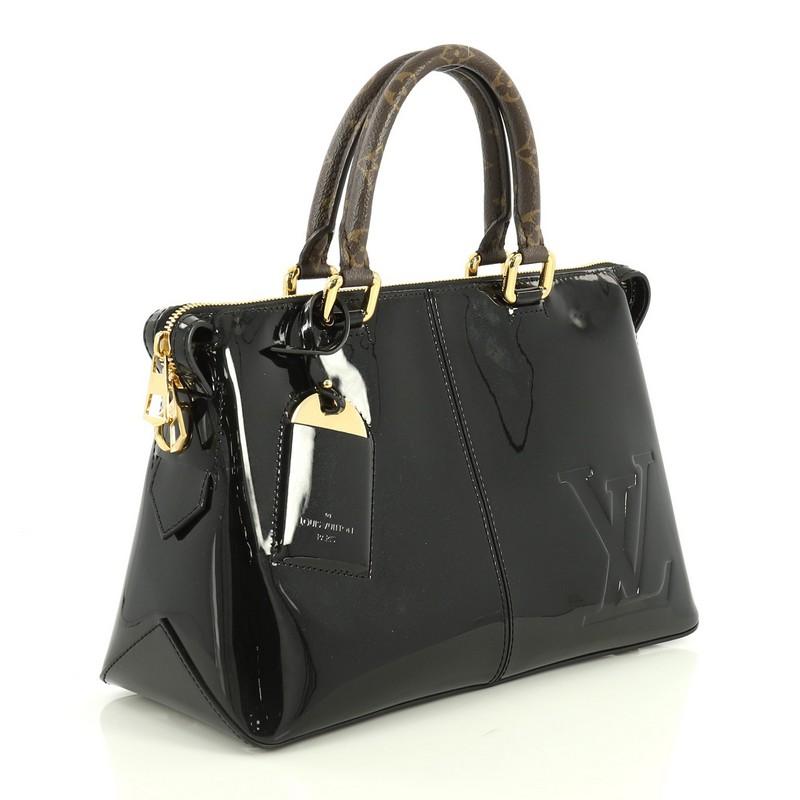 This Louis Vuitton Miroir Handbag Vernis with Monogram Canvas, crafted in black vernis with brown monogram coated canvas, features dual rolled monogram handles and gold-tone hardware. Its zip closure opens to a black fabric and brown monogram coated