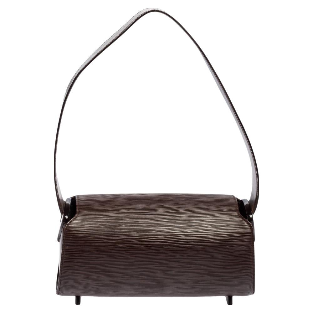 Expertly designed, this Louis Vuitton Nocturne PM bag is an all-time favorite. Crafted from Epi leather, it comes in a lovely shade of brown. It features a single handle, Alcantara-lined interior sized to house essentials, silver-tone hardware, and