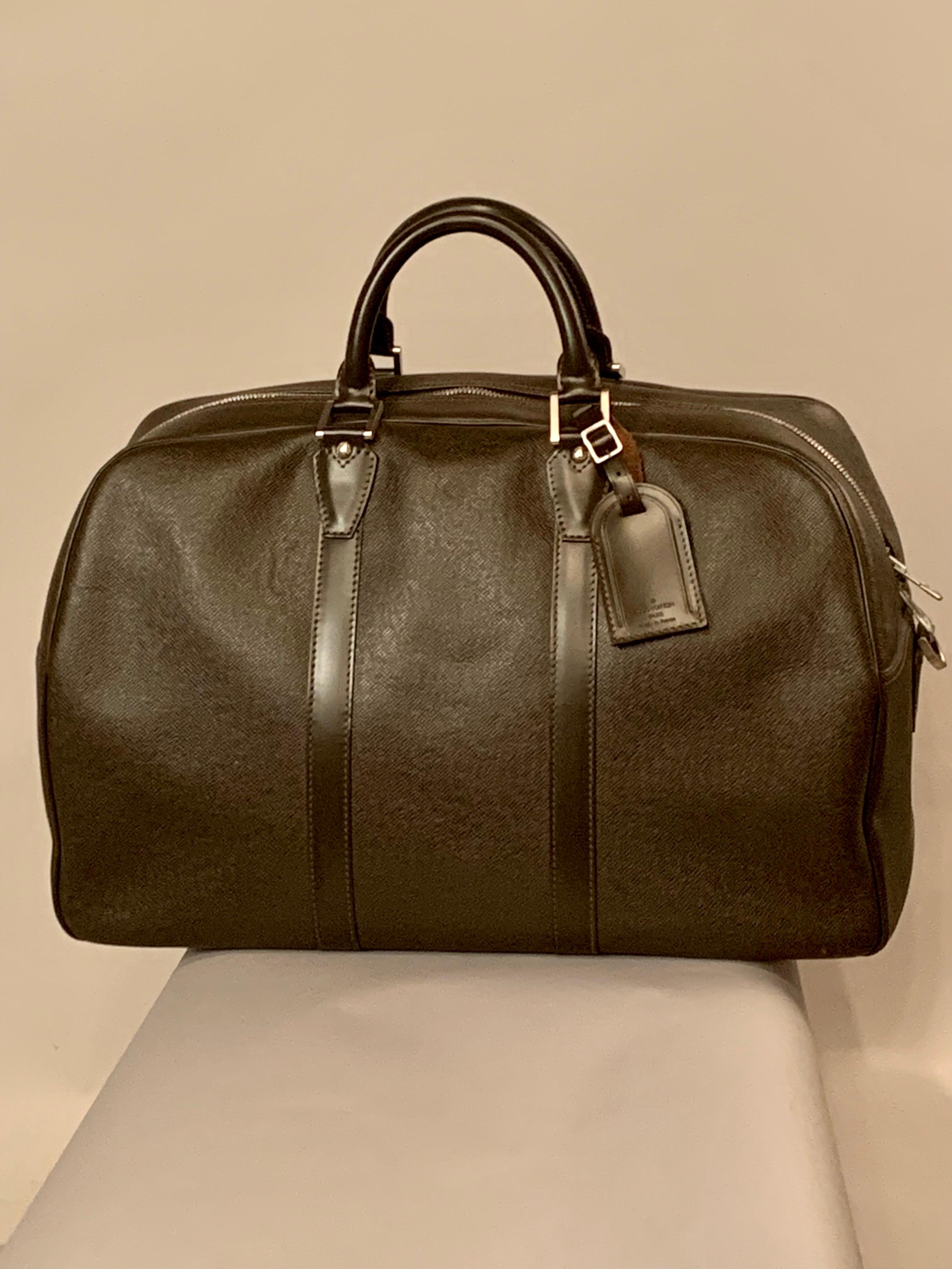 This Louis Vuitton Moka Taiga Carryall bag comes with a Louis Vuitton luggage tag and an adjustable canvas and leather shoulder strap.  The bag has two handles. a center zipper which goes half way down the sides for easy access, and silver tone