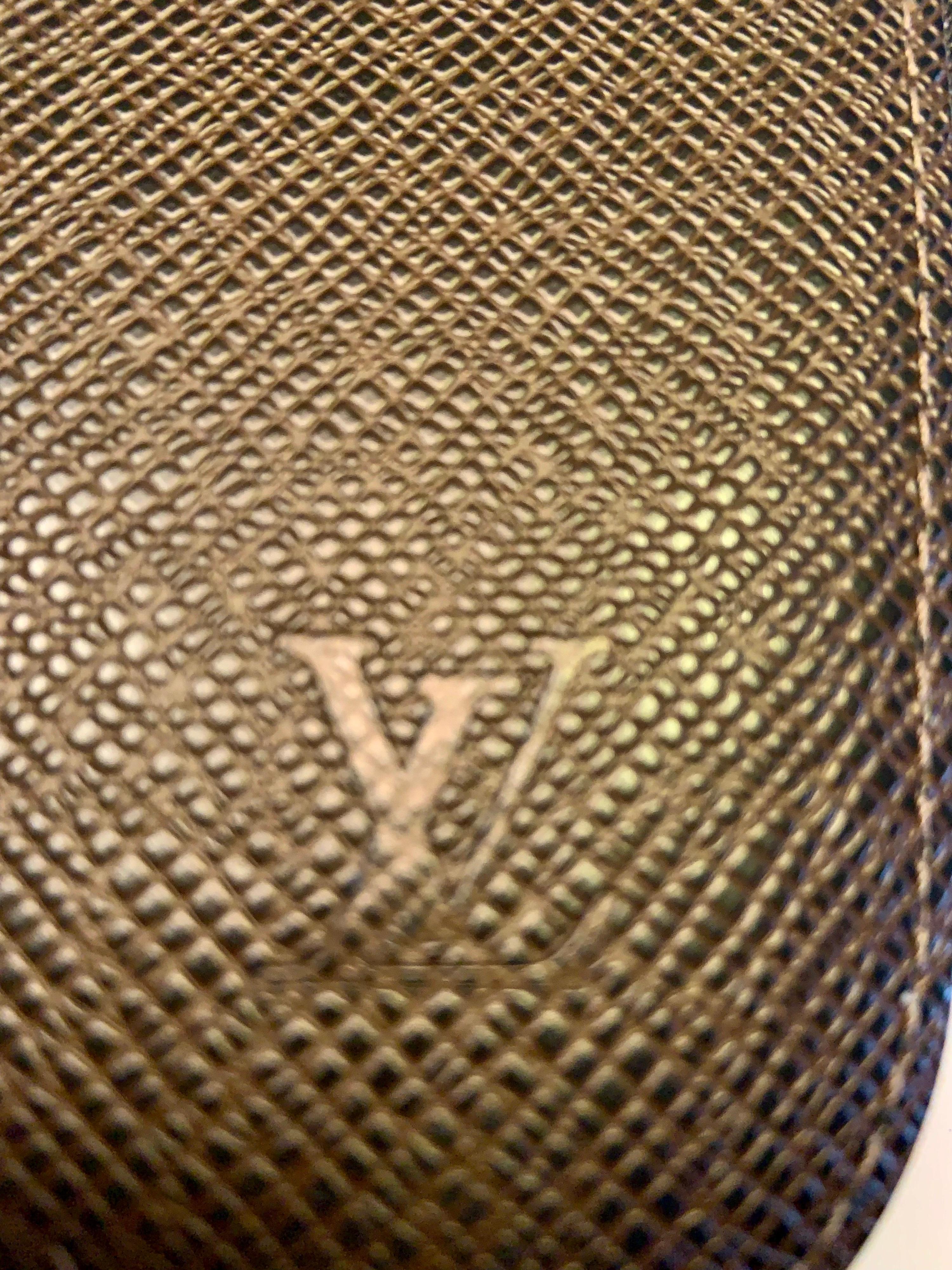 This wonderful Louis Vuitton Moka Taiga leather travel wallet, which can double as a clutch, comes with a black and moka checked pen signed in two places but of so hard to photograph the signature!   The left side of the wallet has two slip pockets