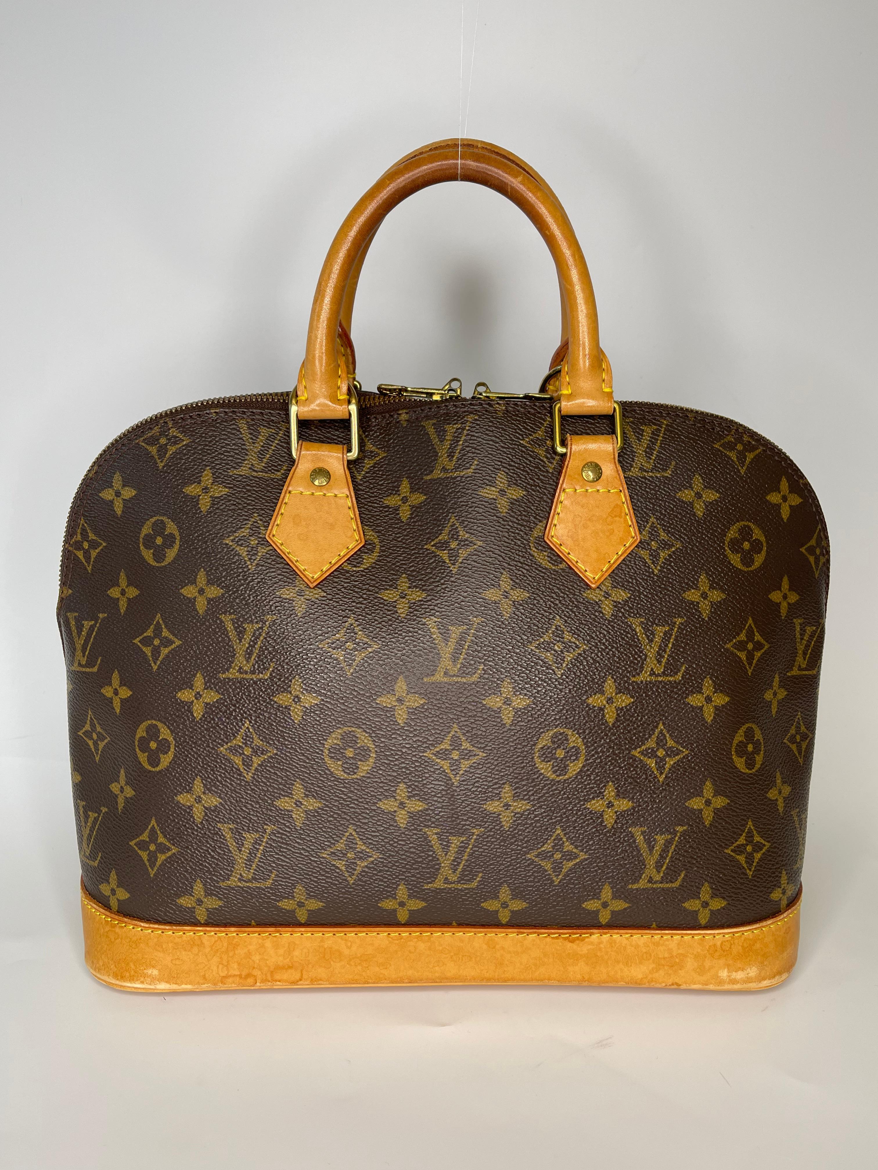 This classic Louis Vuitton bag is an Alma made with brown coated canvas and a gorgeous vechetta leather handles and trim. Features iconic LV zippers and brass hardware, dual top handles, and one large top zipper opening to a beautiful interior, with
