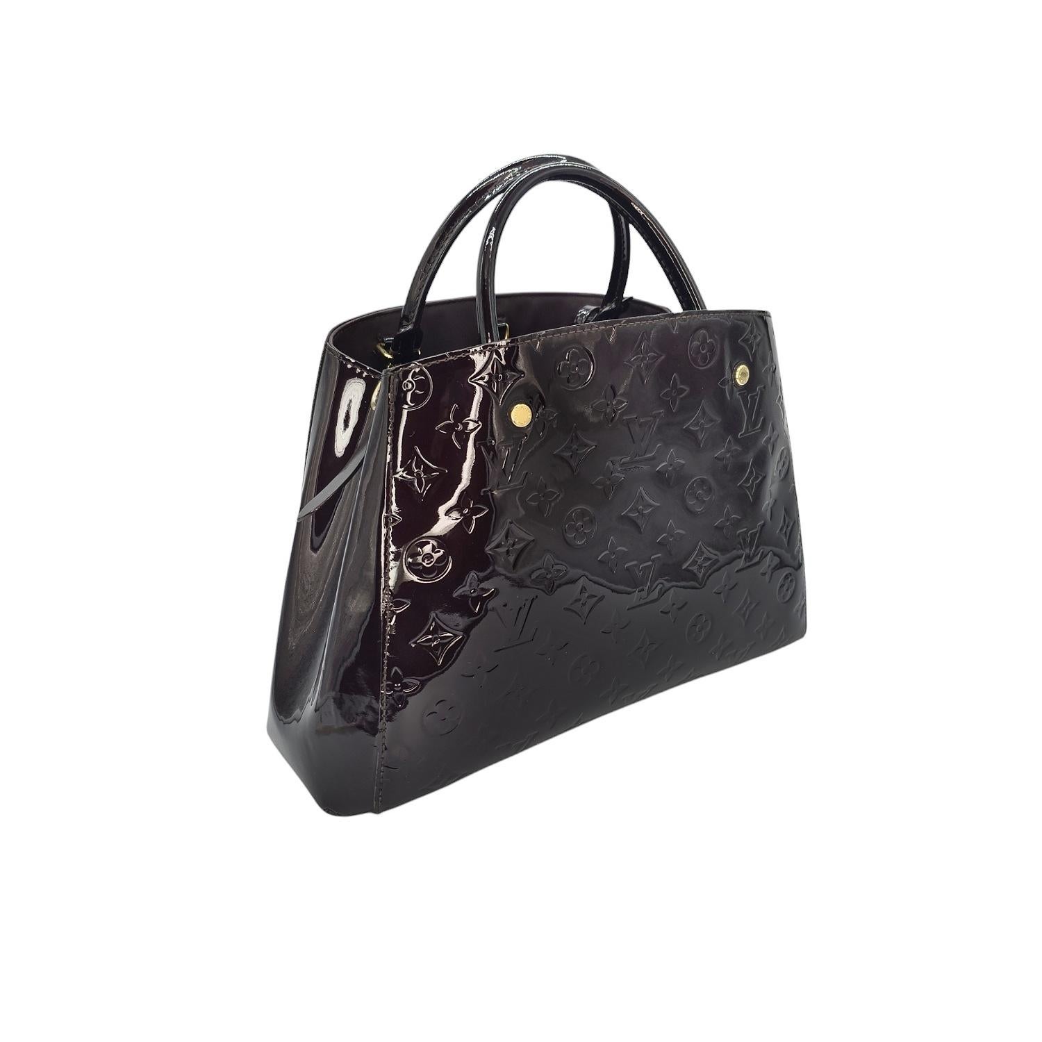 Indulge in pure luxury with the Louis Vuitton Monogram Vernis Leather Montaigne Handbag. Crafted from embossed dark burgundy leather, this sophisticated piece features gold-tone hardware, spacious compartments, and a stylish open-top design. With