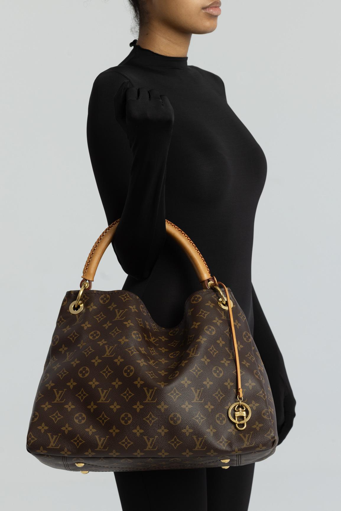 LV Artsy MM. This large tote is made of Louis monogram coated toile canvas. with leather finishes. The bag features a natural vachetta cowhide rolled leather handle with a sleek braided accent, an open, an ivory microfiber interior and an interior