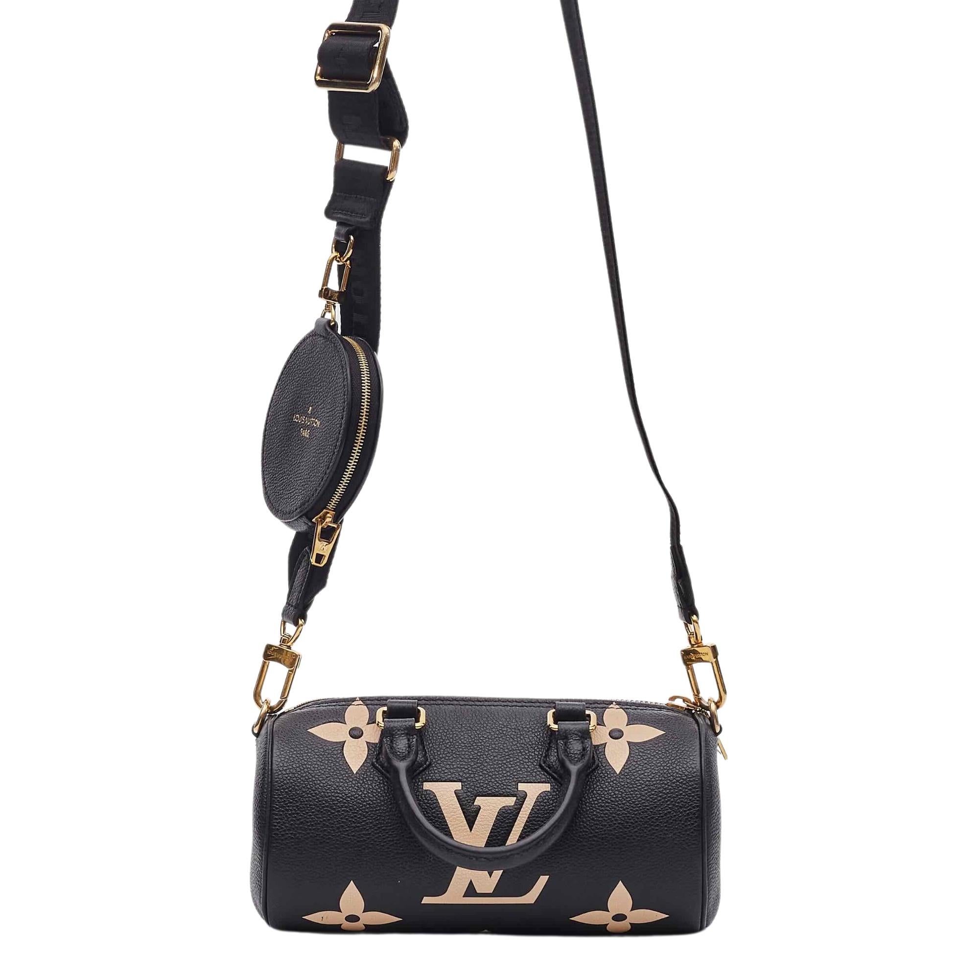 This limited edition barrel-shaped bag is made of traditional empreinte monogram leather in black. It features dual rolled leather top handles and an optional adjustable nylon shoulder strap with a coin purse and gold hardware. The top zipper opens