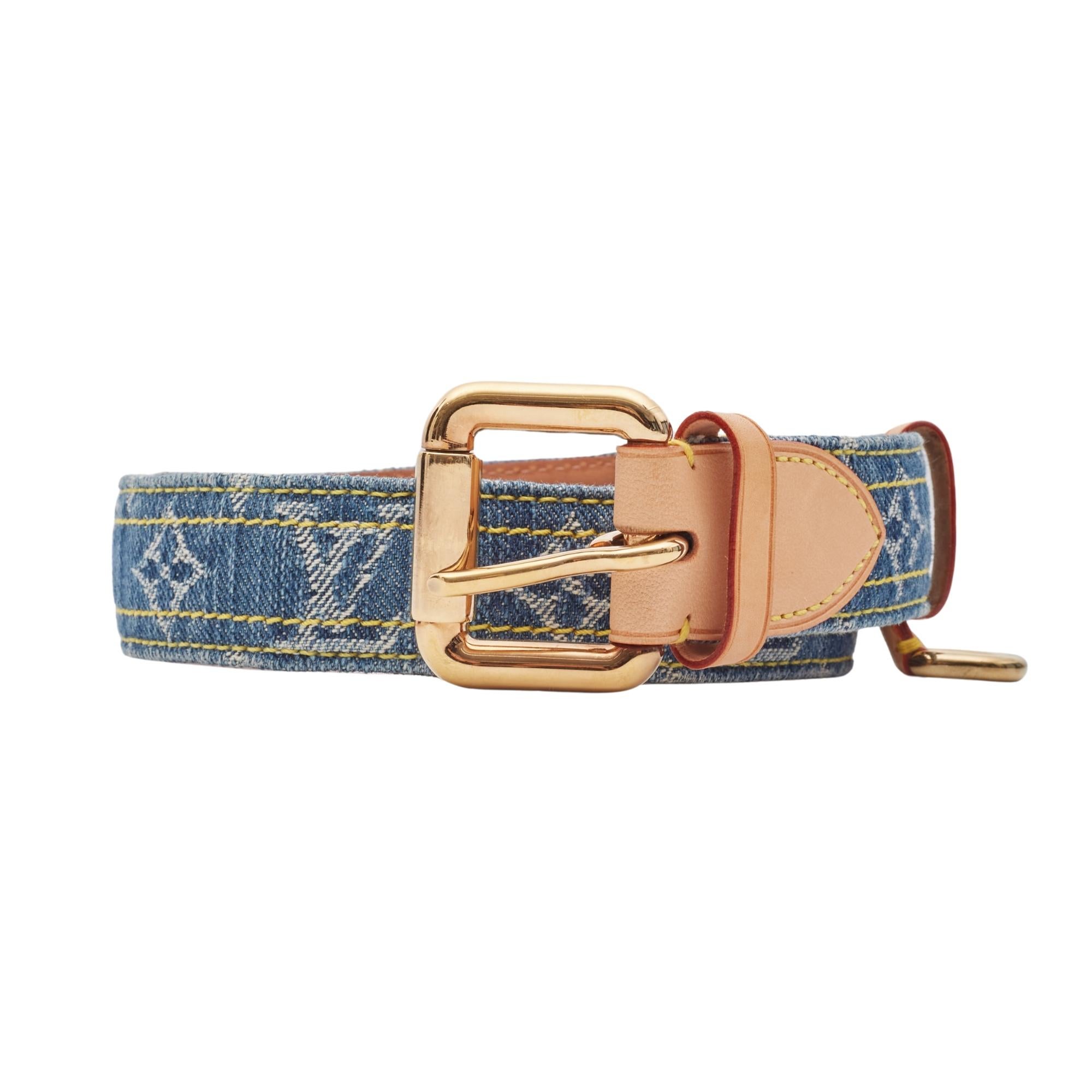 This Louis Vuitton belt is from the 2006 collection and is made with vachetta cowhide leather and blue denim on the exterior.  The belt features blue denim with monogram print throughout, gold tone hardware, leather accents and a polished brass